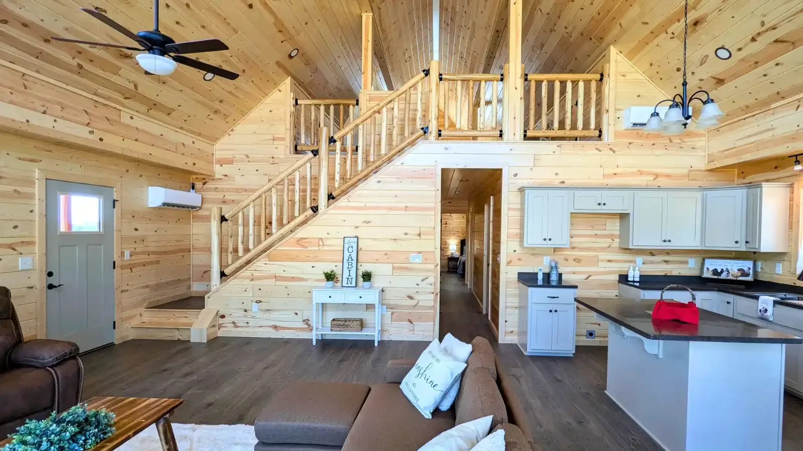 Amish Built Cabins Vaulted Interior 2 level lofted Log Cabin, showing living room, front entry, double landing stairs, kitchen, and hallway, available in all 50 states with up to 100% financing through BuildBuyRefi Home Loans