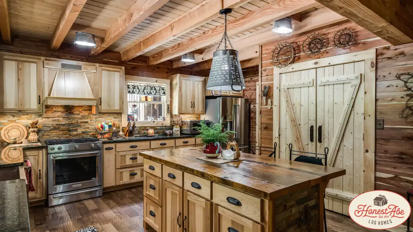Interior Kitchen by Honest Abe Log Cabins with Center Island, Built in Gas Range, Stone Backsplash, Stainless Appliances, Double Door Panty, Exposed Ceiling Headers, custom lighting with up to 100% financing at BuildBuyRefi.com