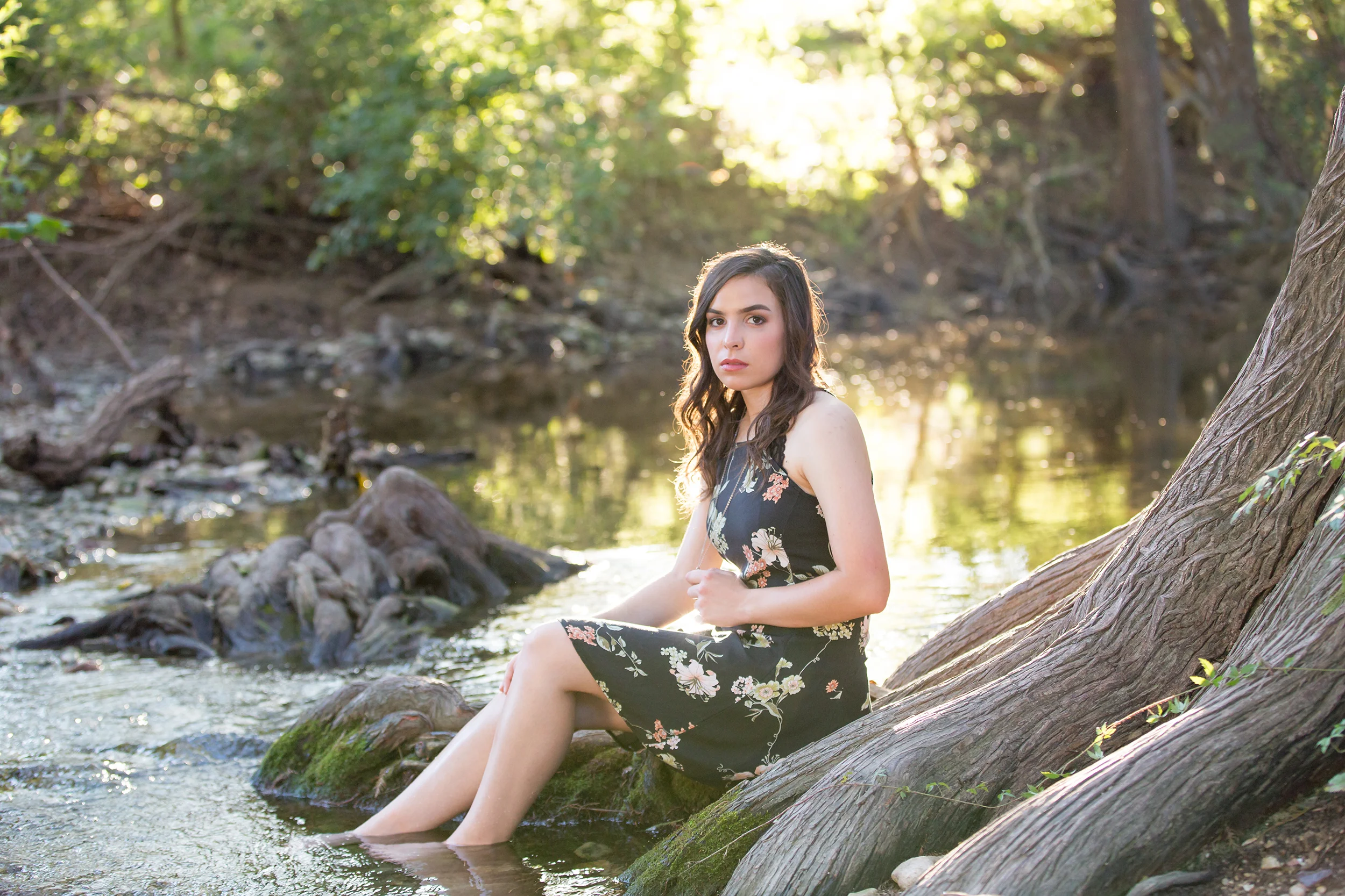 Senior-girl-sitting-tree-river-sun-backlight.jpg