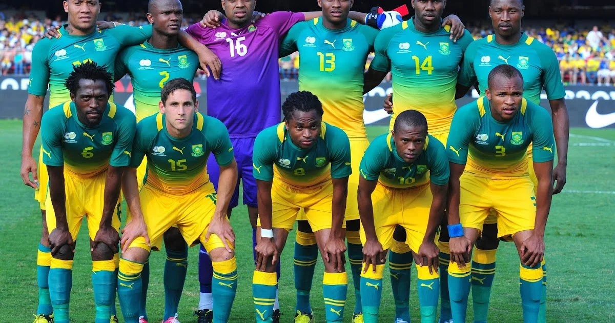 Soccer team in green and yellow uniforms lined up for a team photo on the field