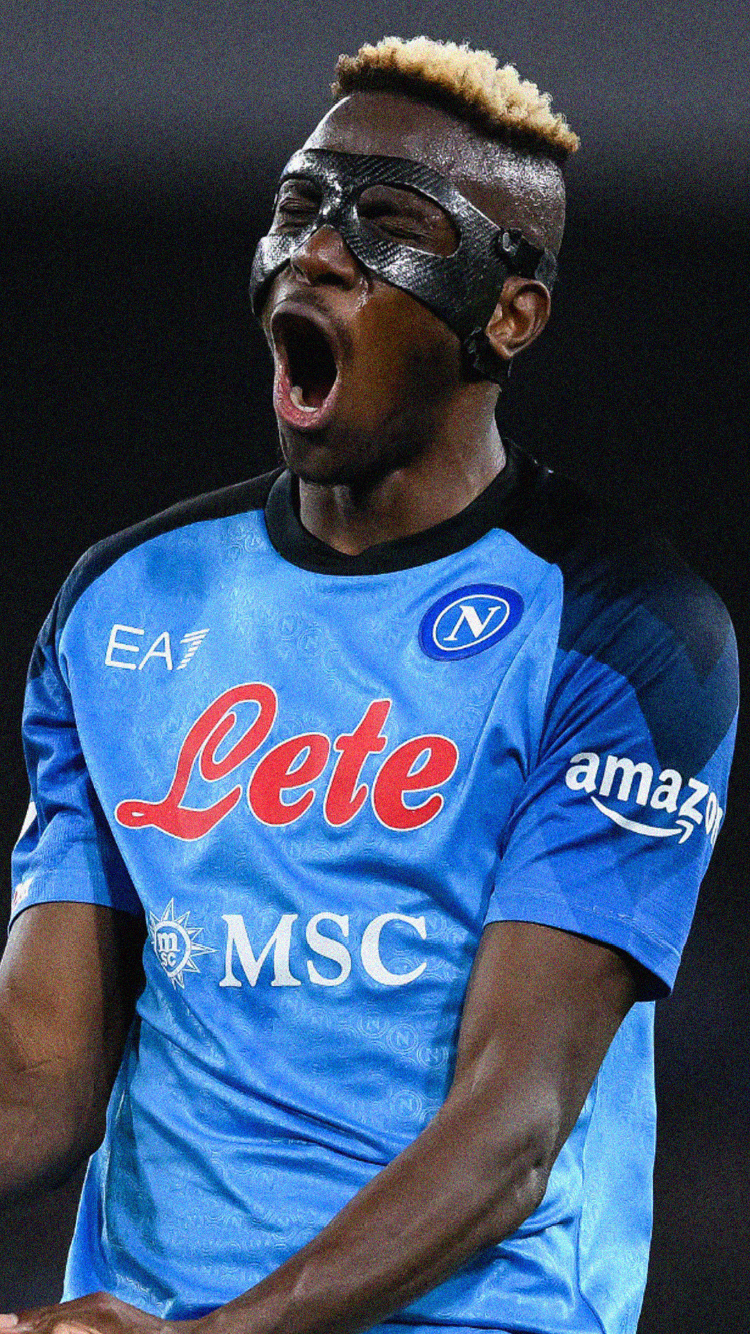 A soccer player wearing a Napoli jersey with his mouth open, wearing a black mask, with short light-colored hair.