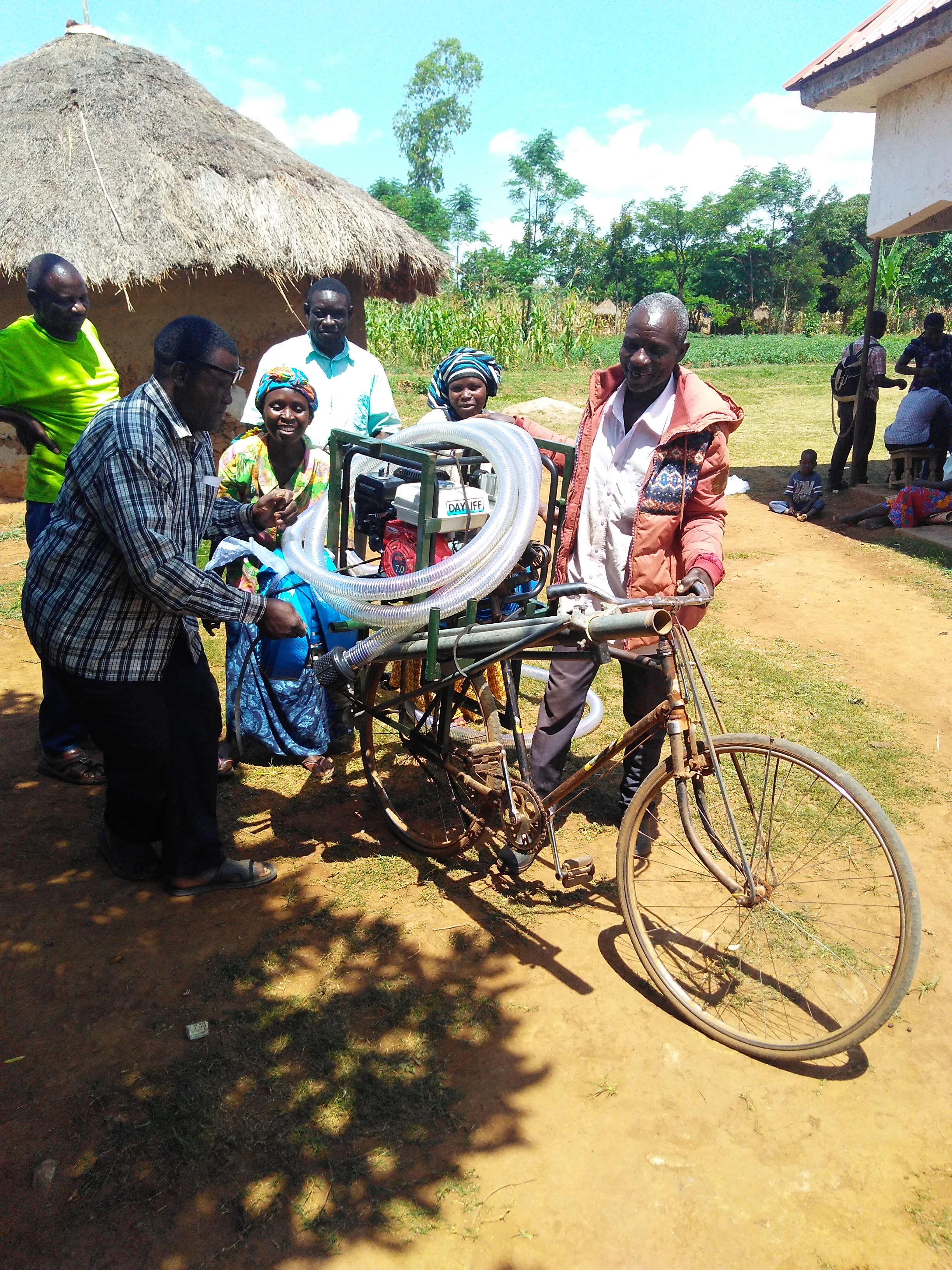 Shareable—and moveable—irrigation. Farmers at Tente hand off the bicycle-carry irrigation system, which is maintained by the irrigation group and circulated among members.