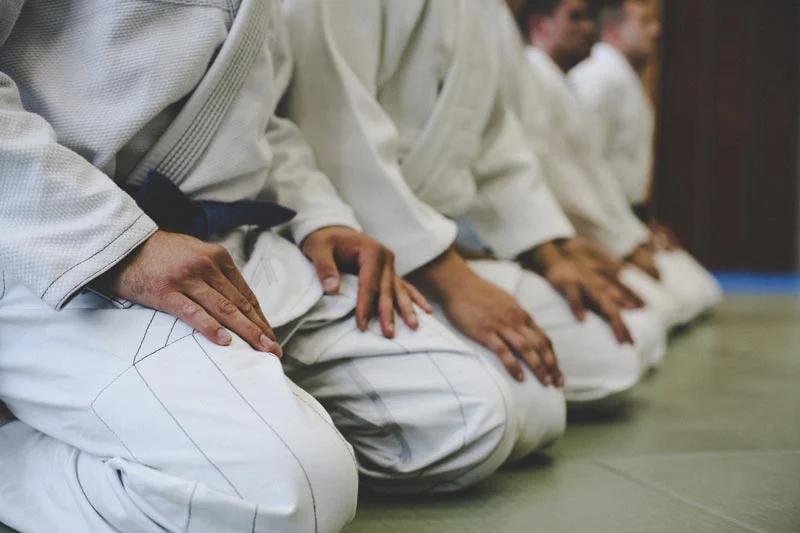 how-bjj-works-students-at-bjj-gym-line-up-in-rank-iStock-946060408.jpg