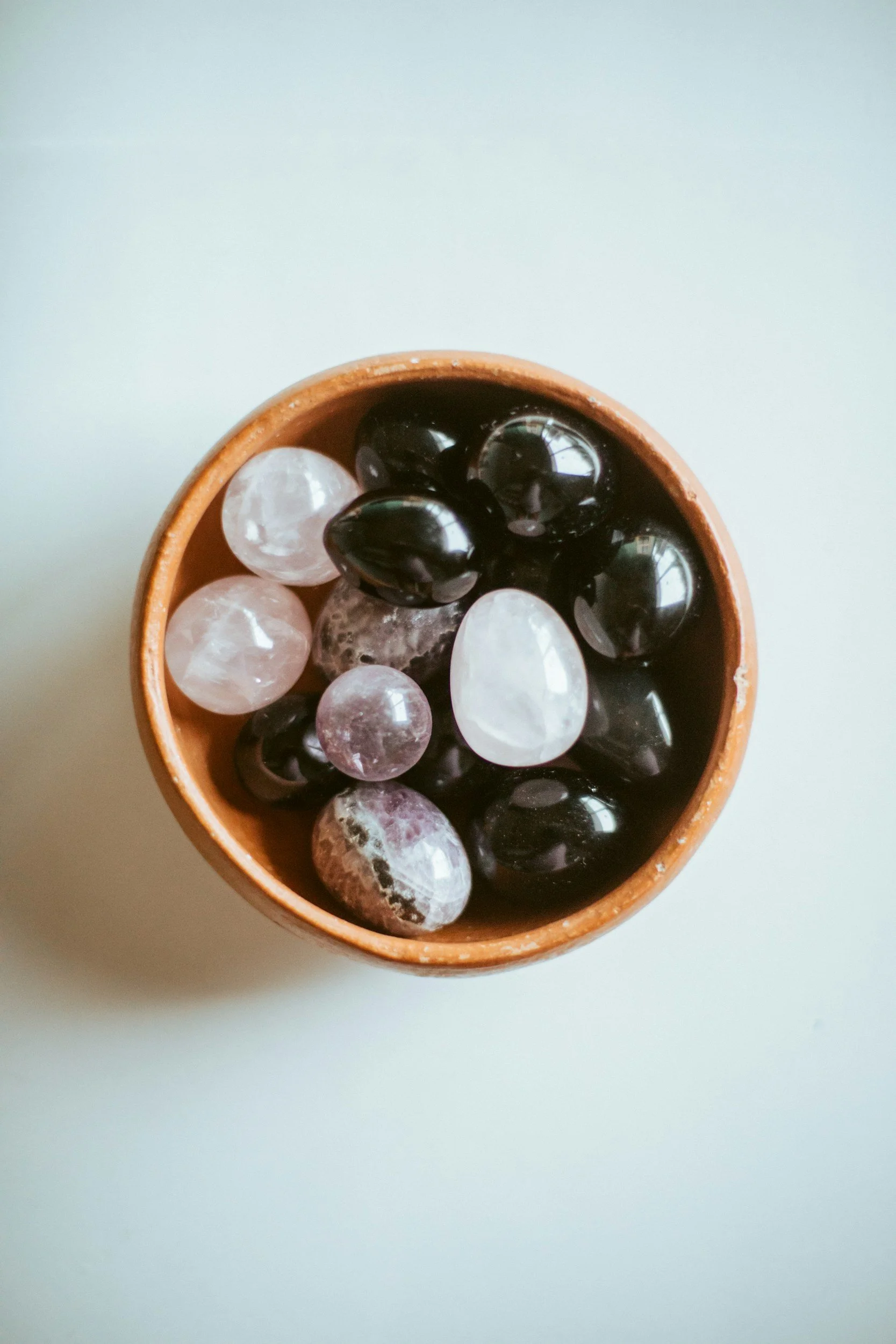 Healing stones in bowl showing the healing that will take place with Obsidian Counseling and Wellness when engaged in EMDR intensives to address trauma, anxiety, and depression in Illinois