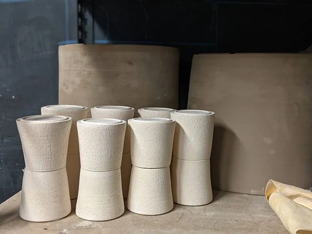 Some tumblers, waiting for glaze. One of the two big pots behind them is in the bisque kiln as I type this, the other will be fired in a week or so. Almost time for another round of glazing!
