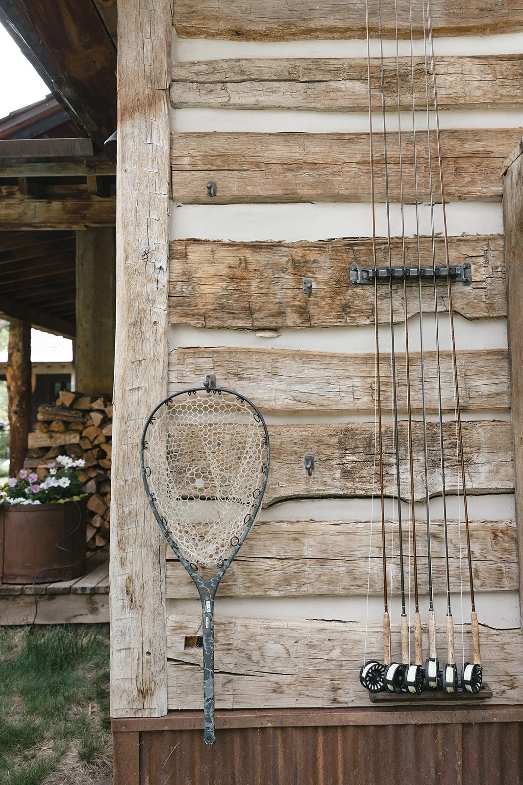 Fishing poles and net hanging on outside of cabin