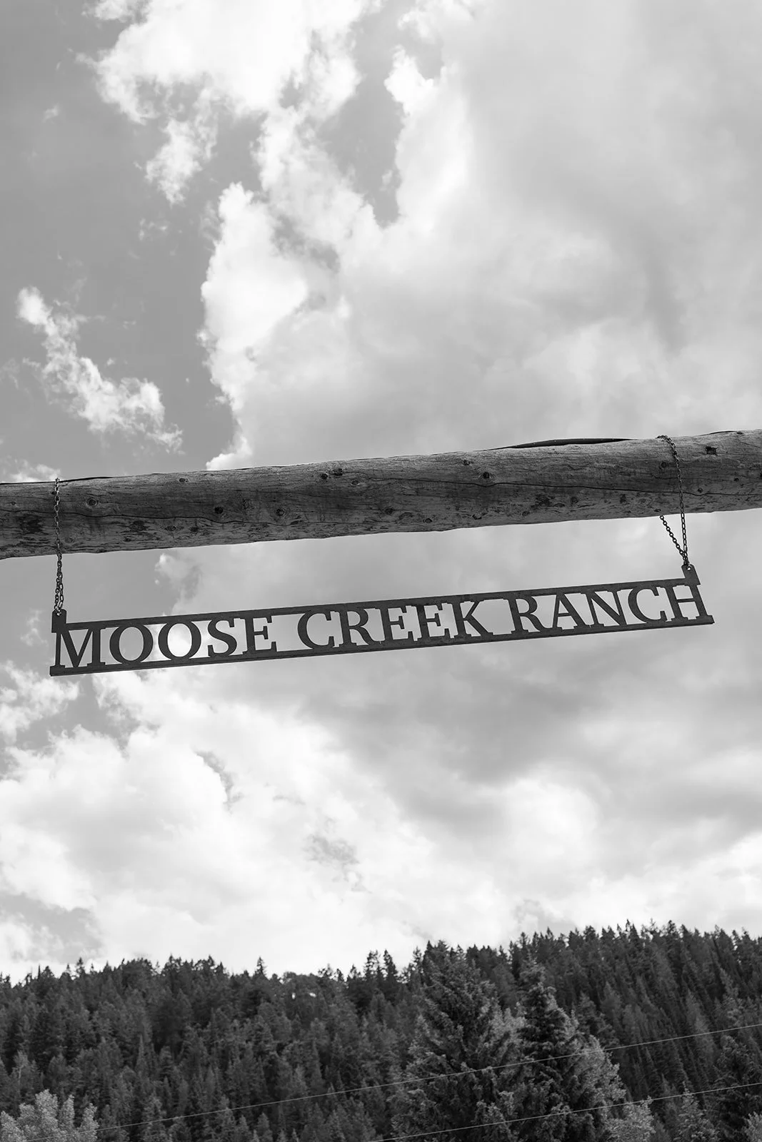 Moose Creek Ranch sign hanging from wooden beam