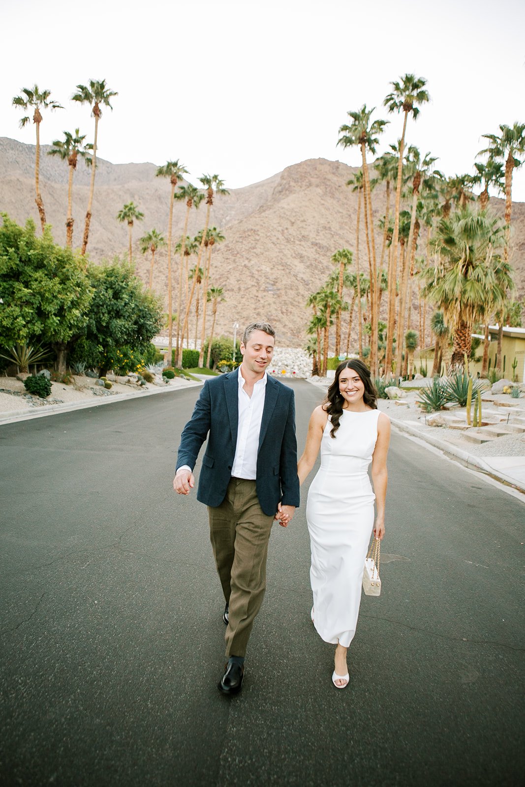 Bride and groom holding hands walking towards camera