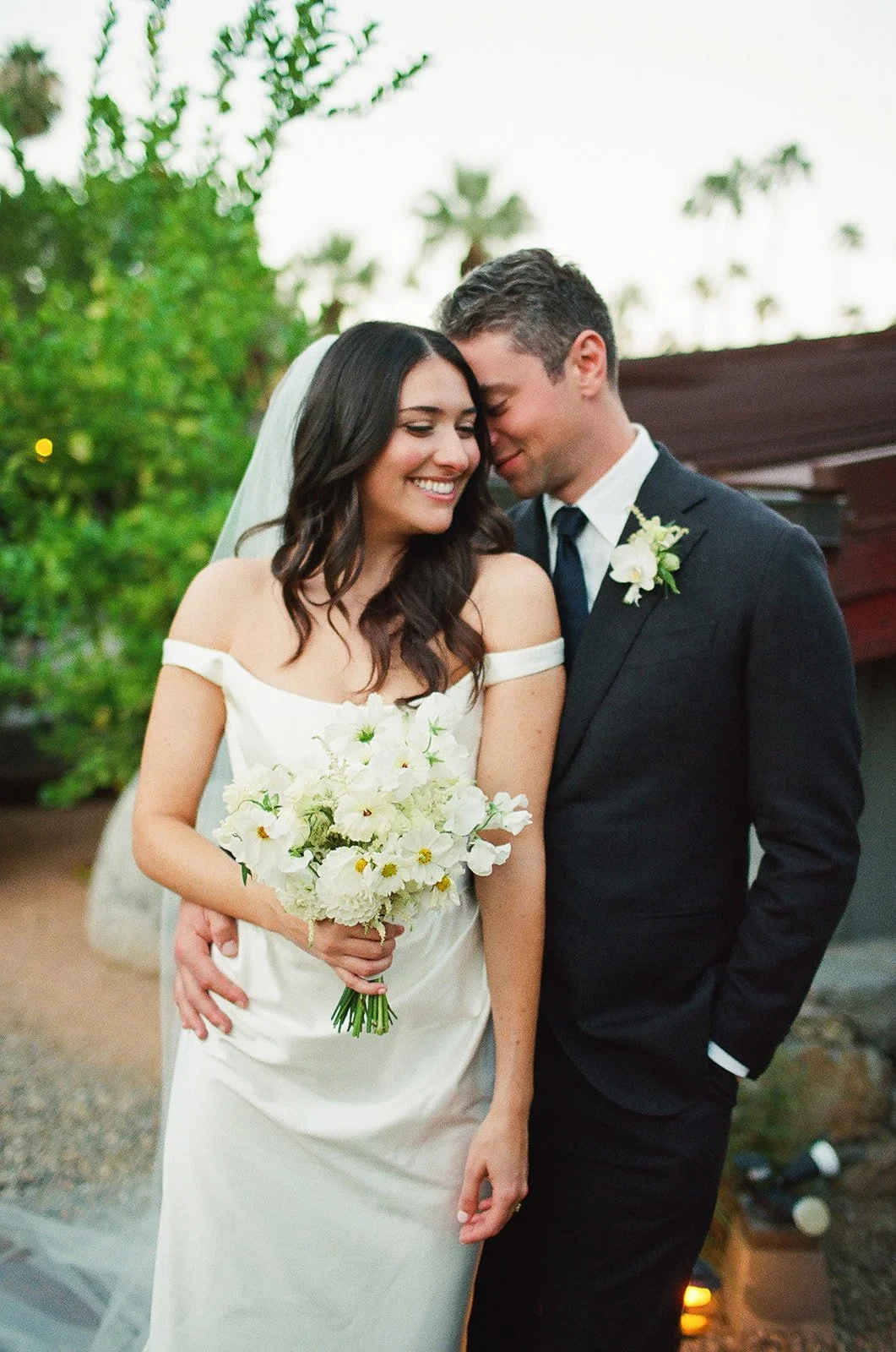 Bride and groom just married with veil and flowers