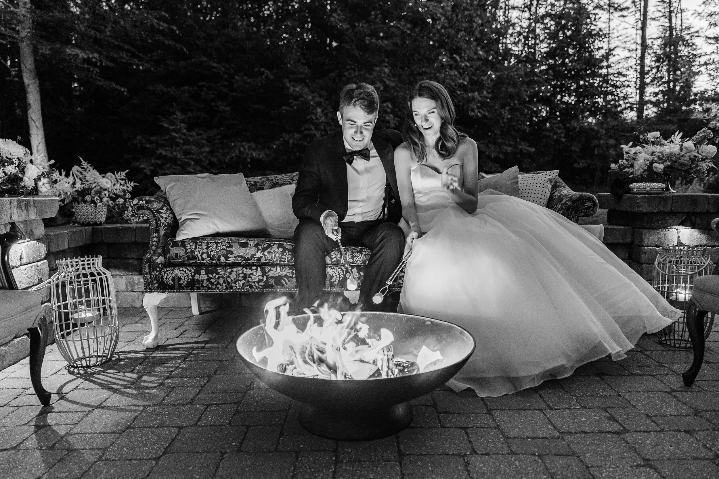 timeless couple making s'mores at their summer wedding reception