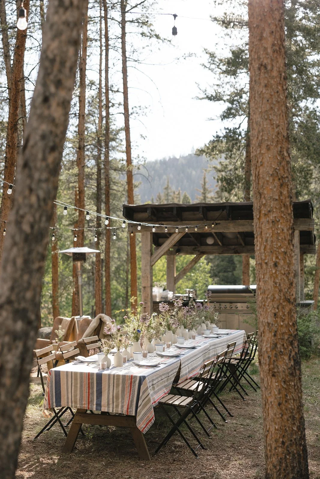 Table with flowers set for guests outside with mountains overhead