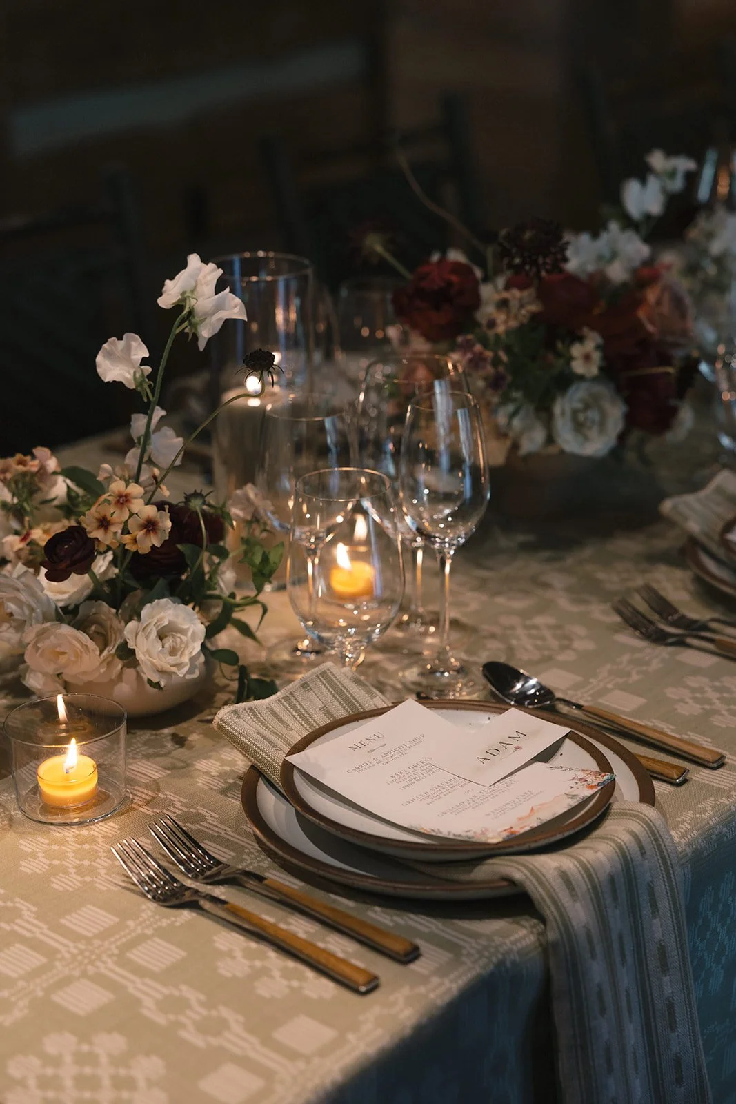 Place setting with lit candles at dinner table
