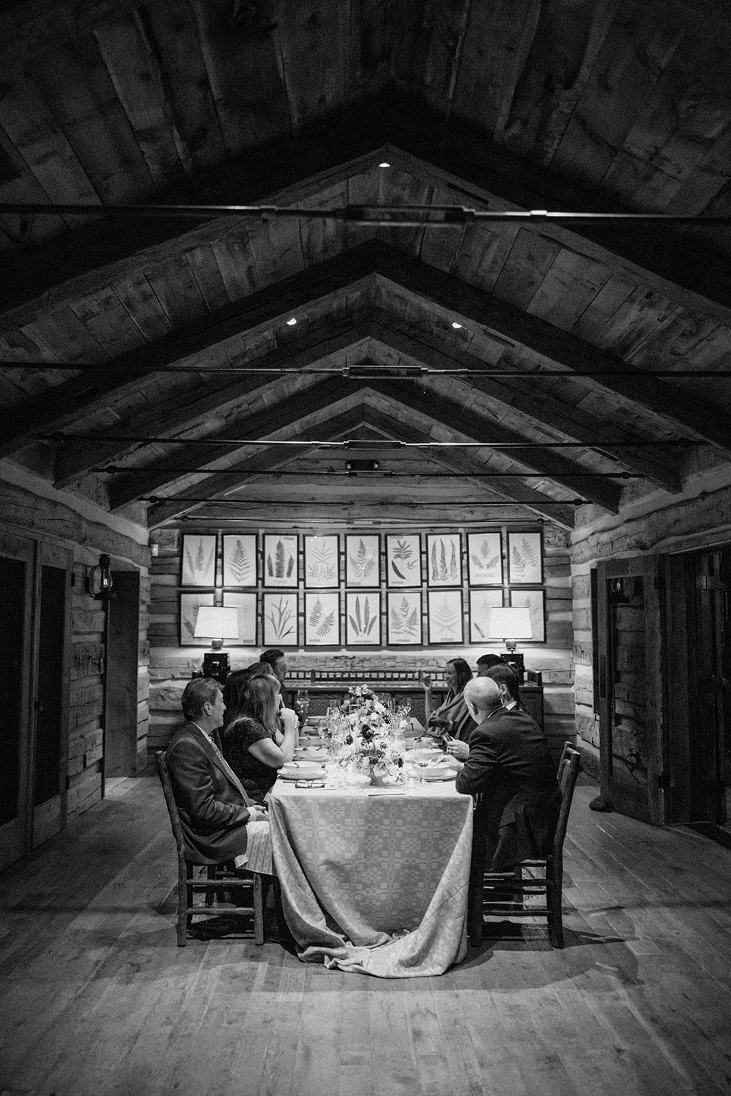 Guests sitting at reception table in log cabin