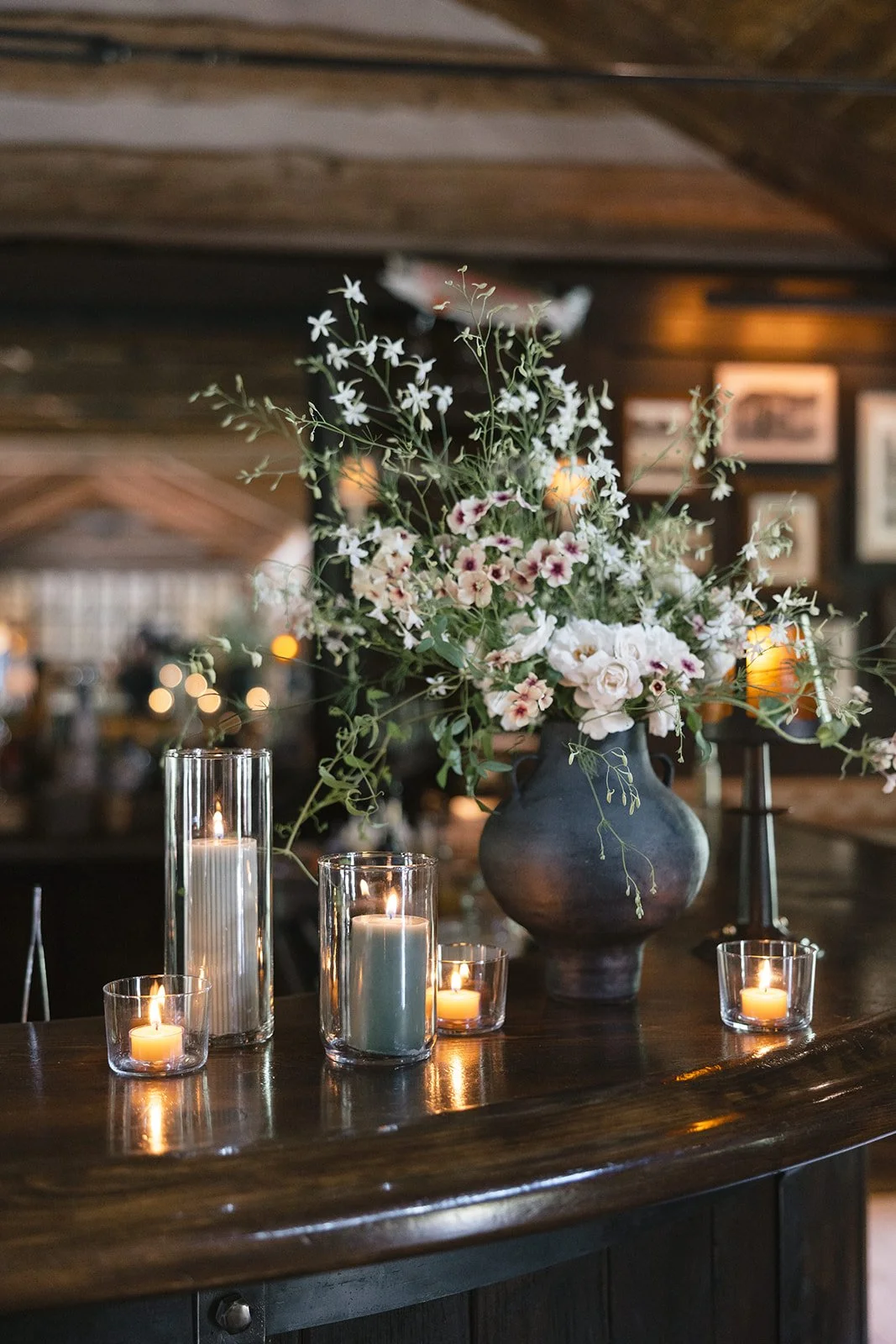 Floral arrangement sitting on bar with candles lit