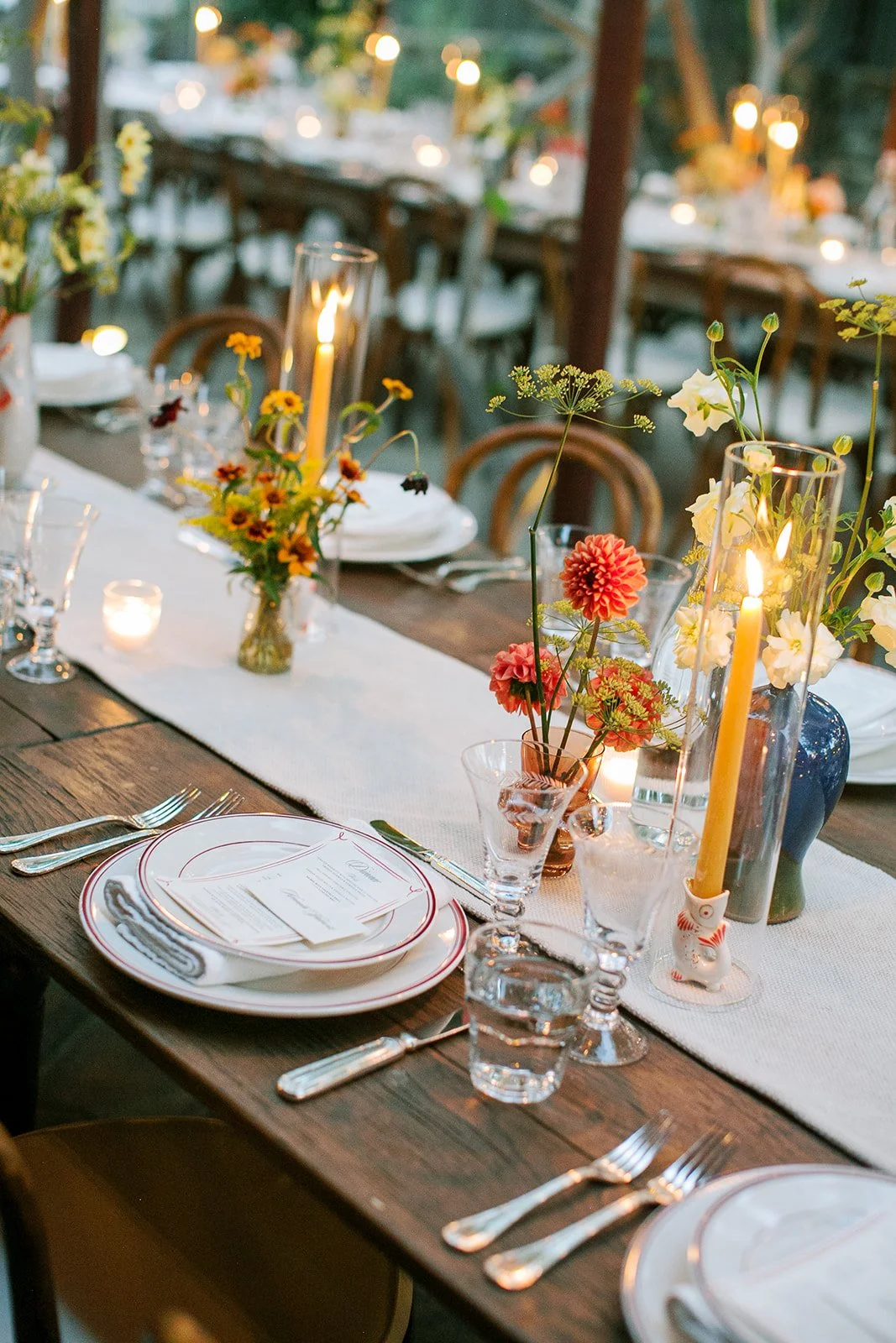 Table setting with menu and place cards on it with candles lit