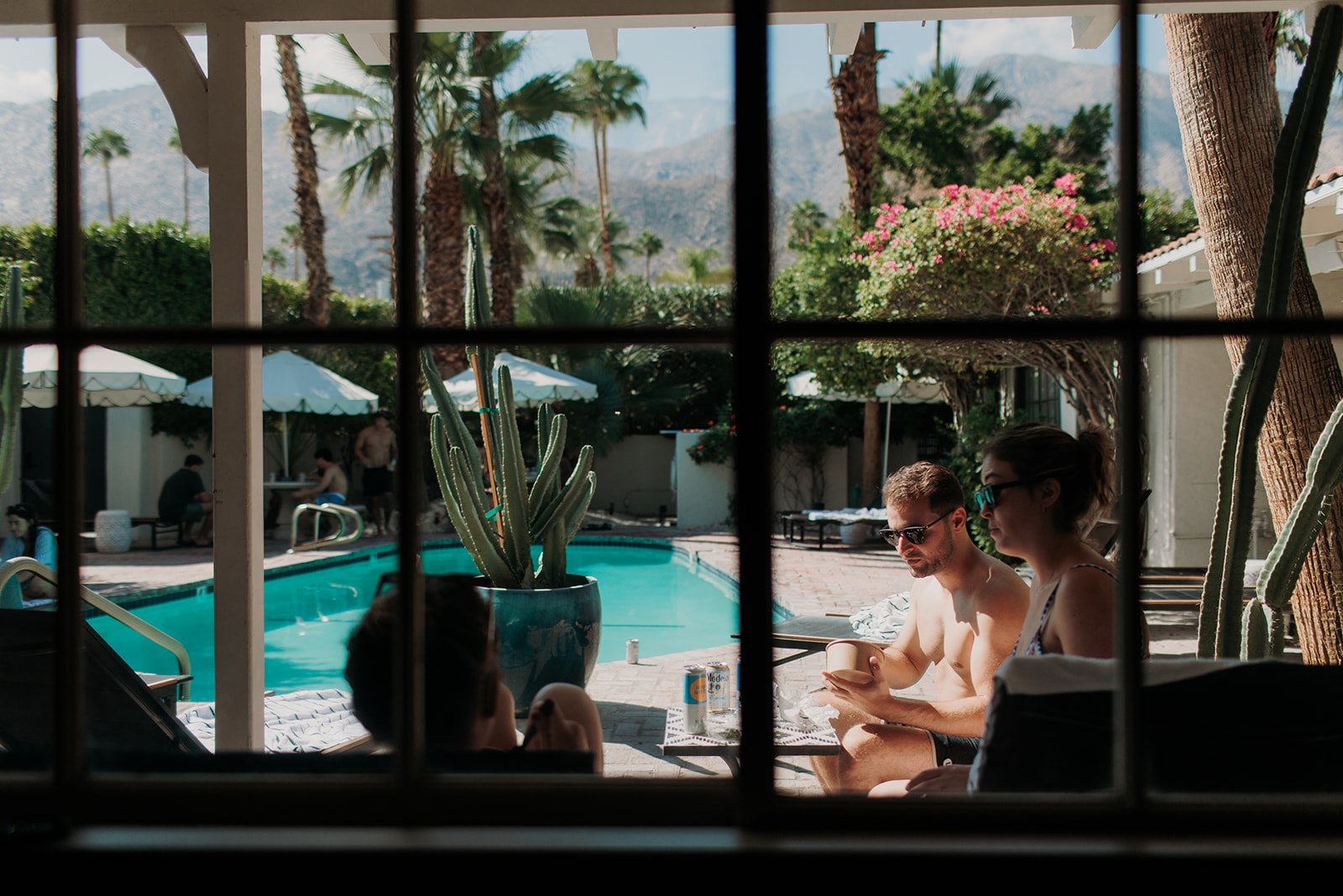 Wedding guests sitting around the pool with drinks