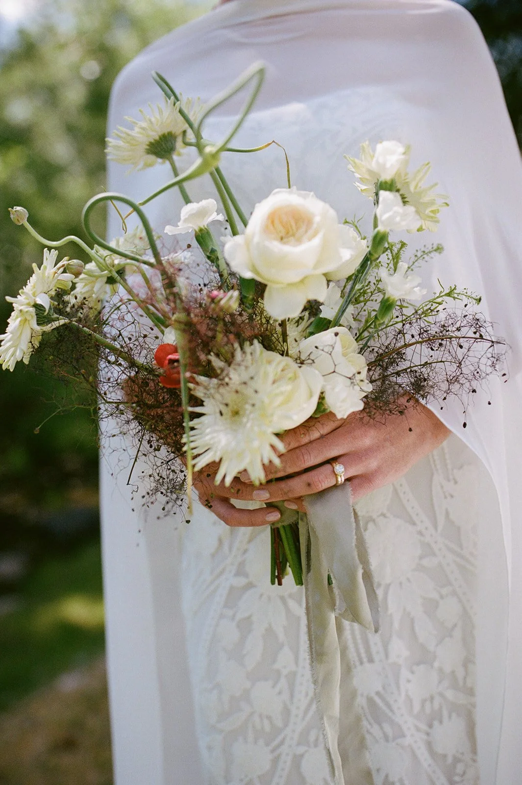 Bride holding floral arrangement with her dress on