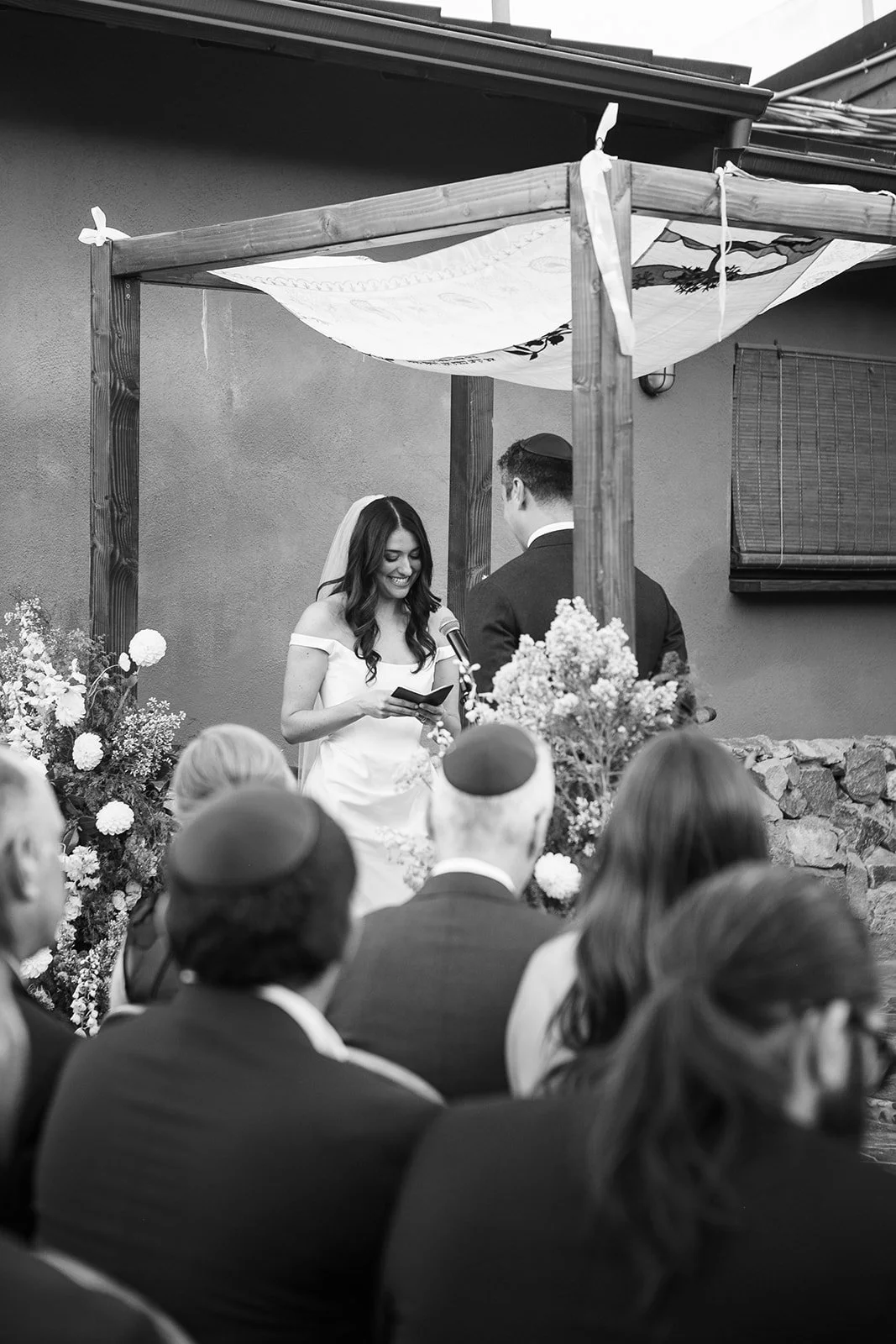 Bride reading her vows under chuppah