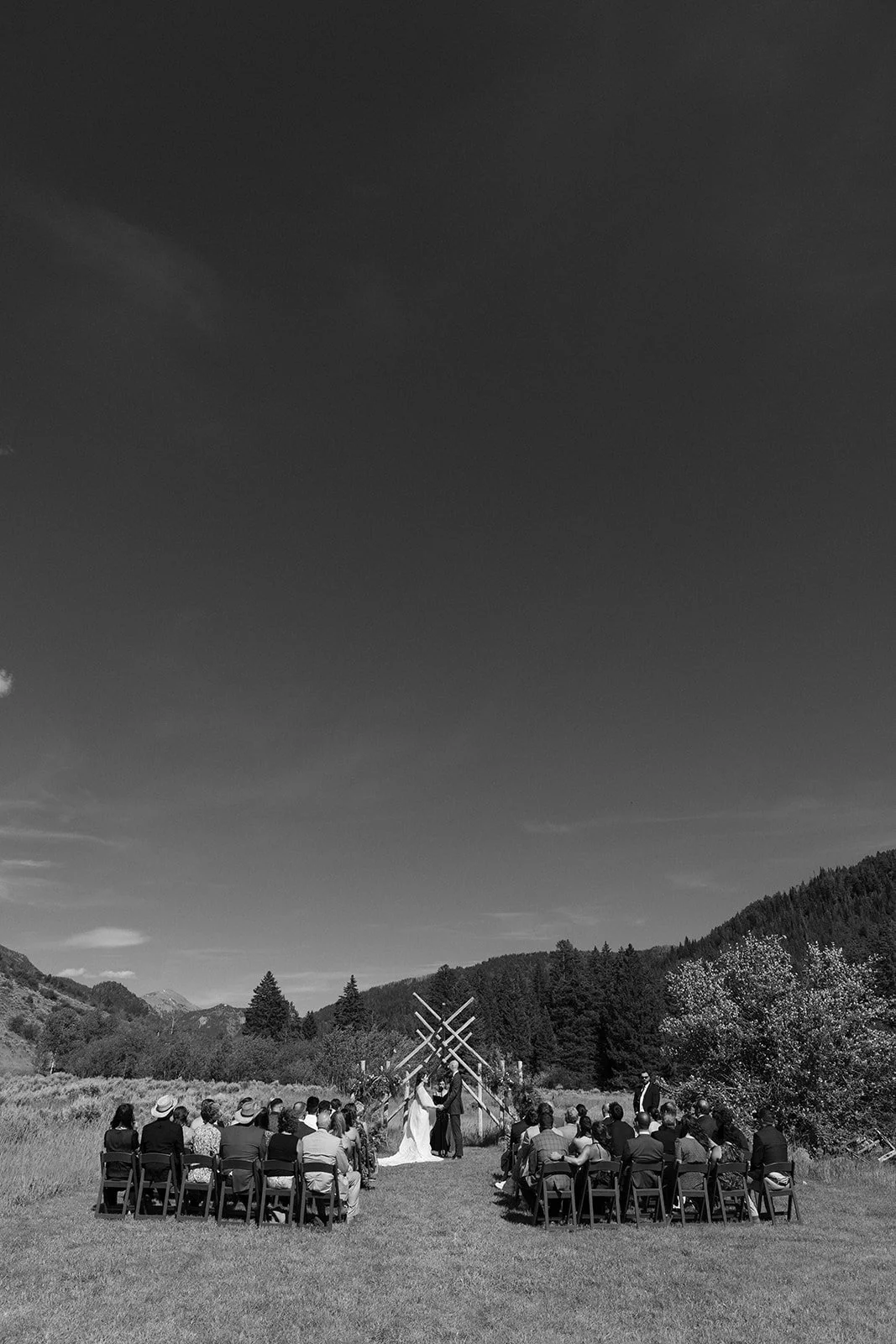 Black and white of wedding ceremony outside in mountains
