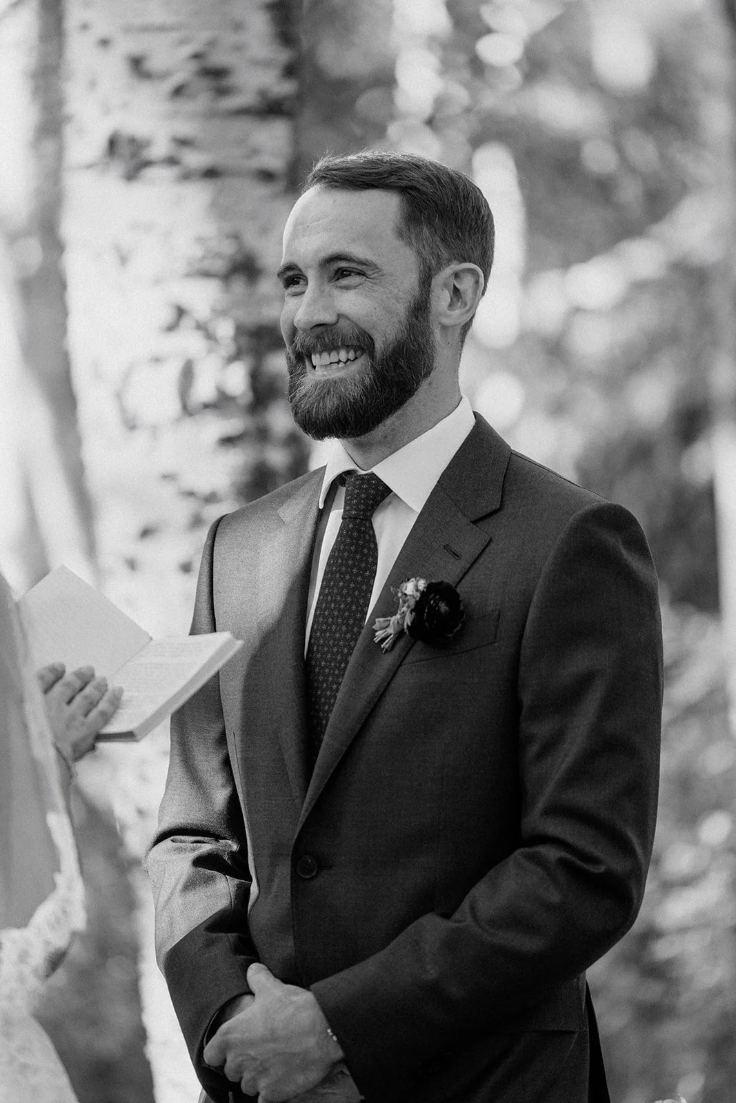 Groom smiling while bride reads her vows