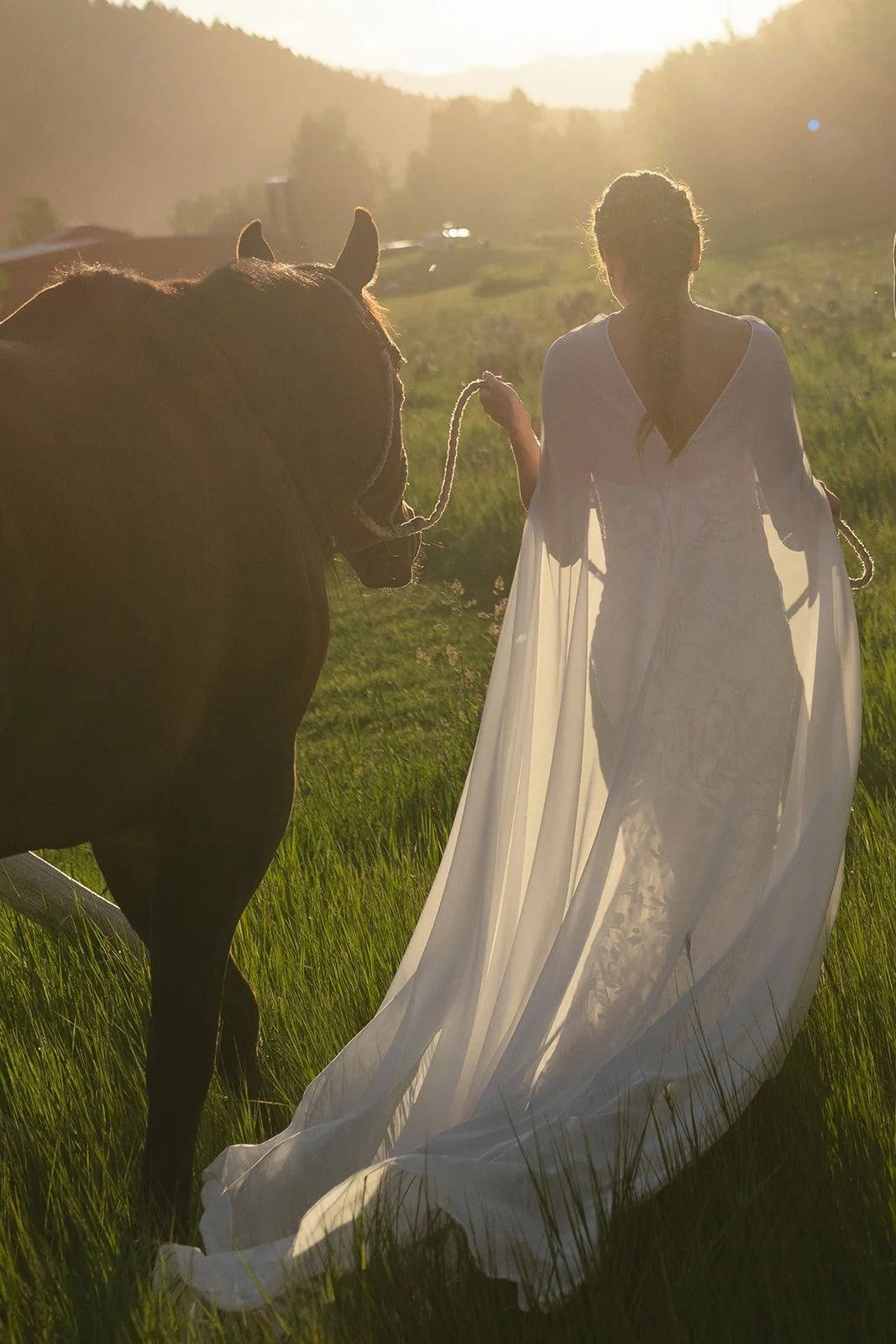 Bride walking in field while leading horse