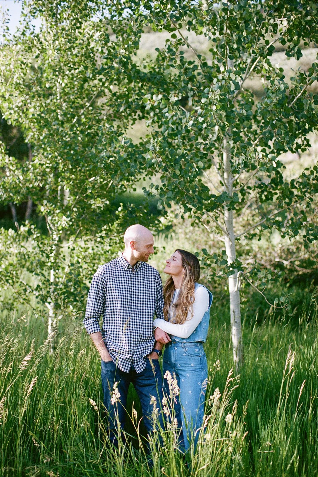 Bride and groom smiling together among trees