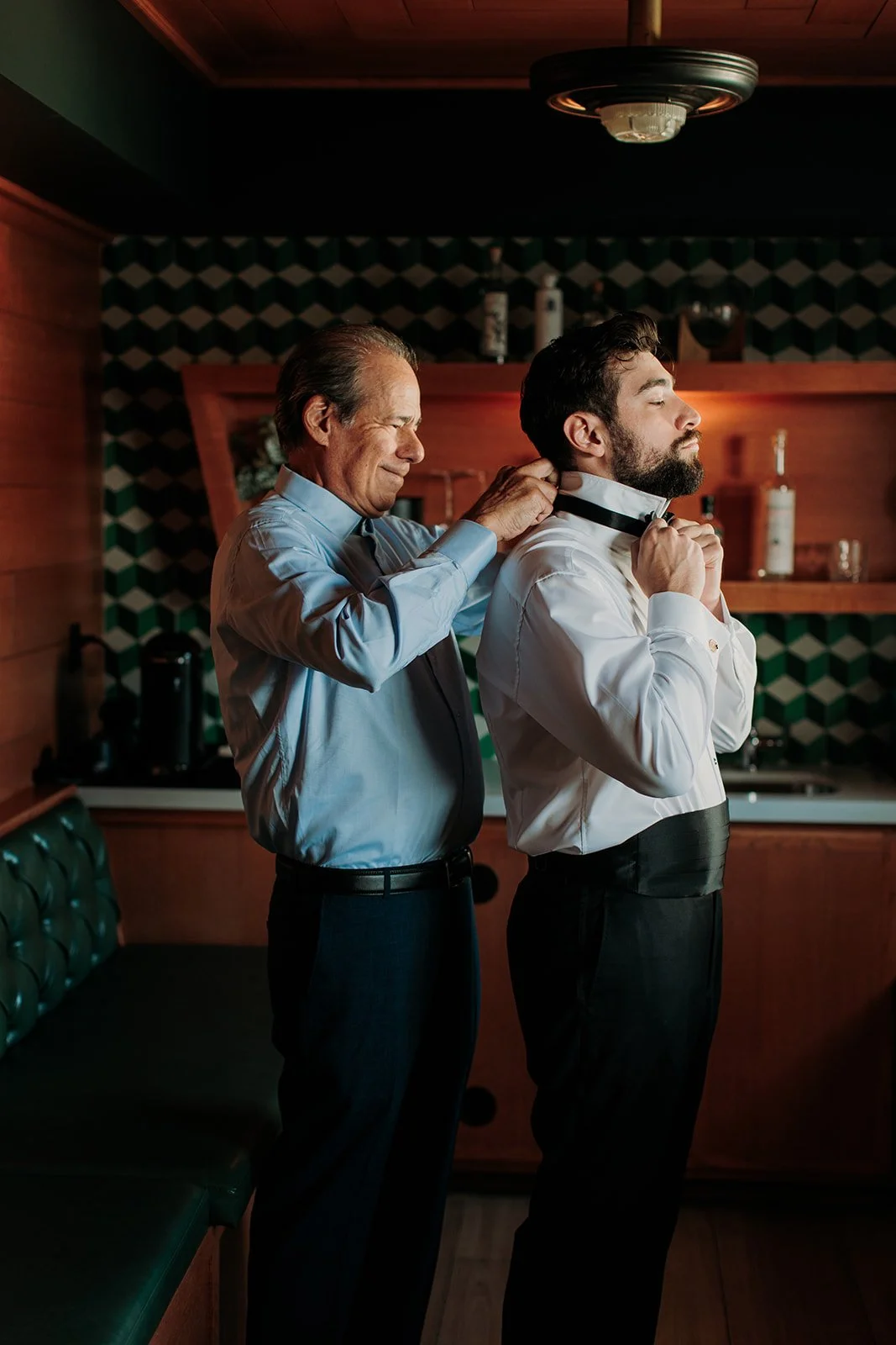 Groom's father helping him put bowtie on