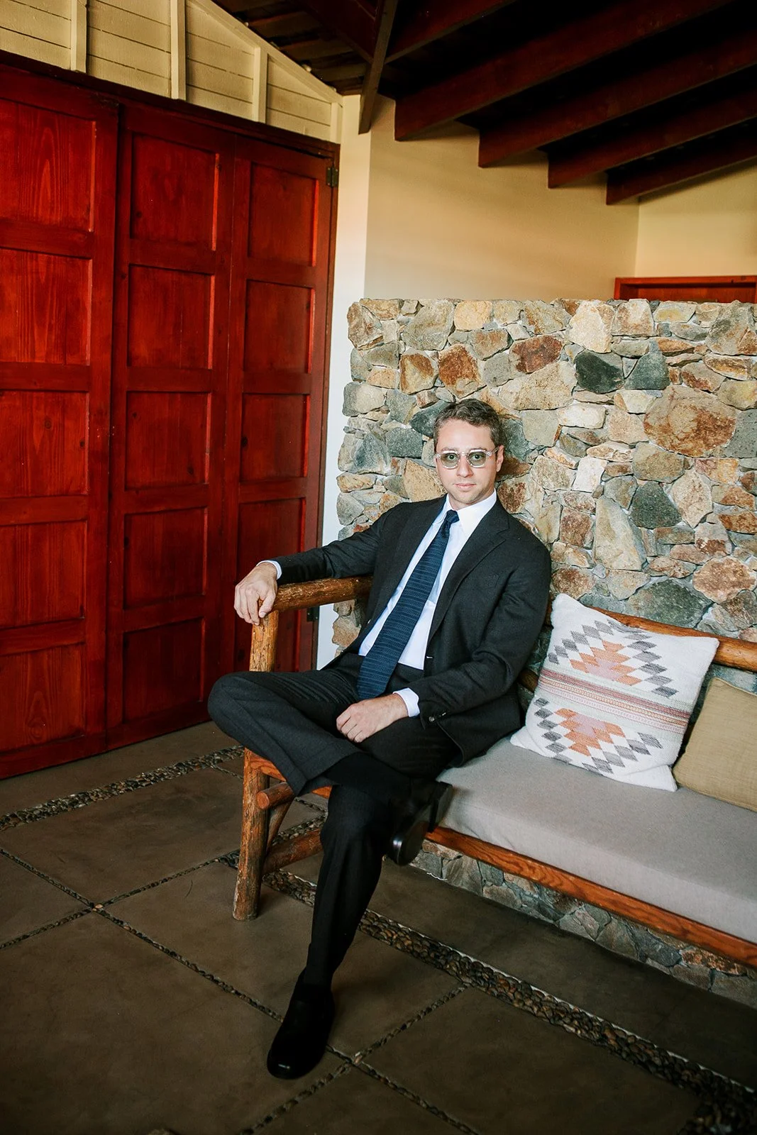 Groom sitting in suit on bench