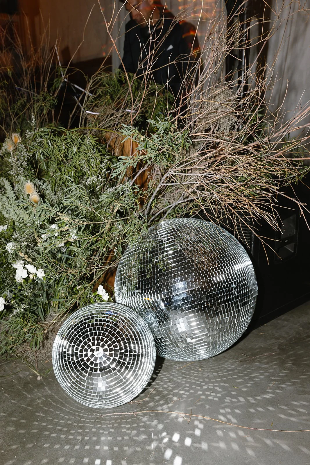 Disco balls and floral arrangement sitting on dance floor