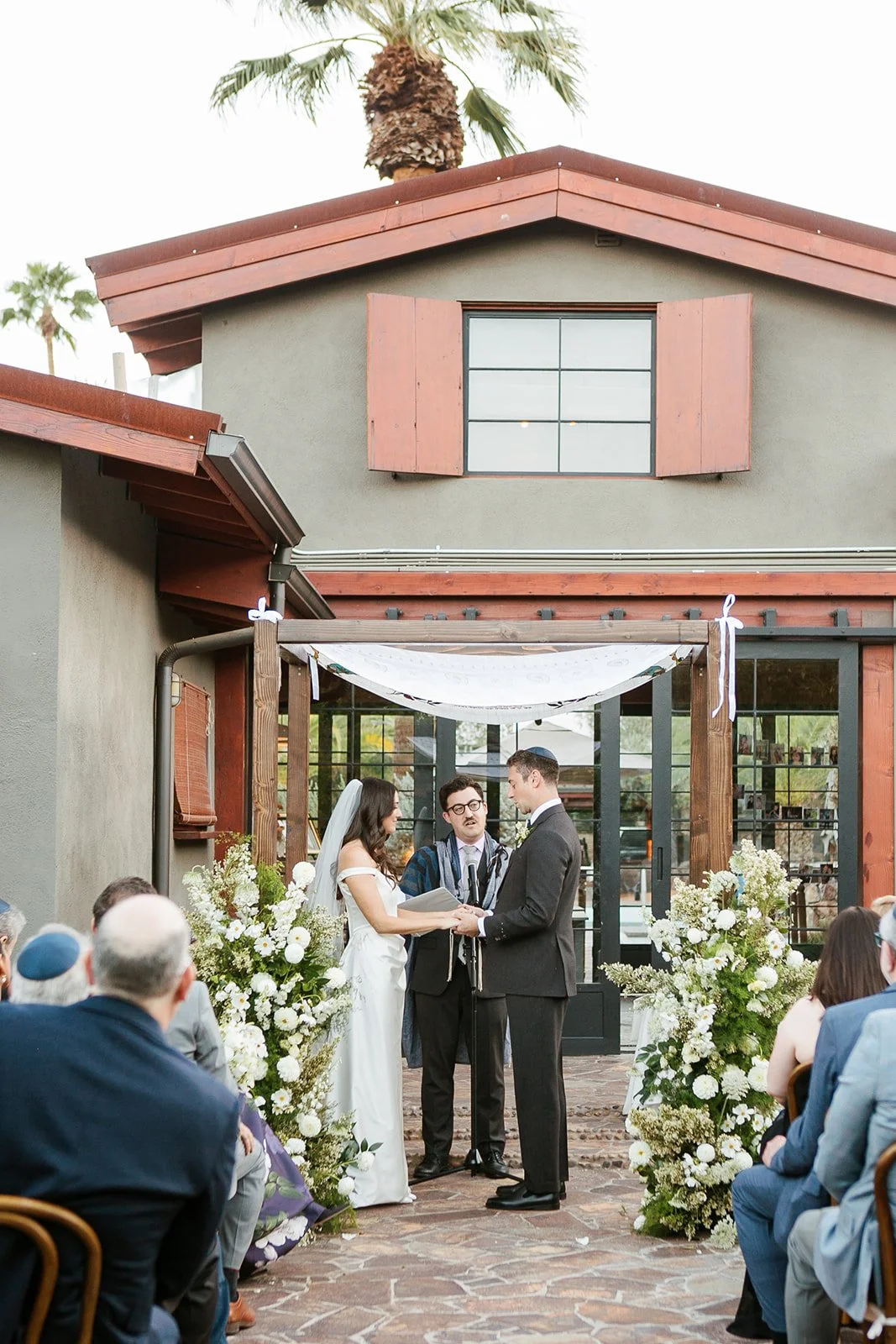 Bride and groom under chuppah during ceremony