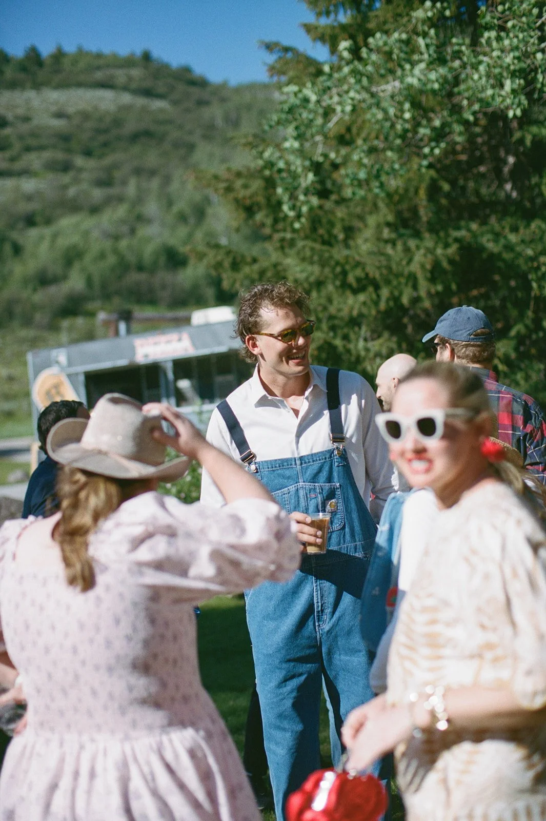 Wedding guests mingling dressed in overalls