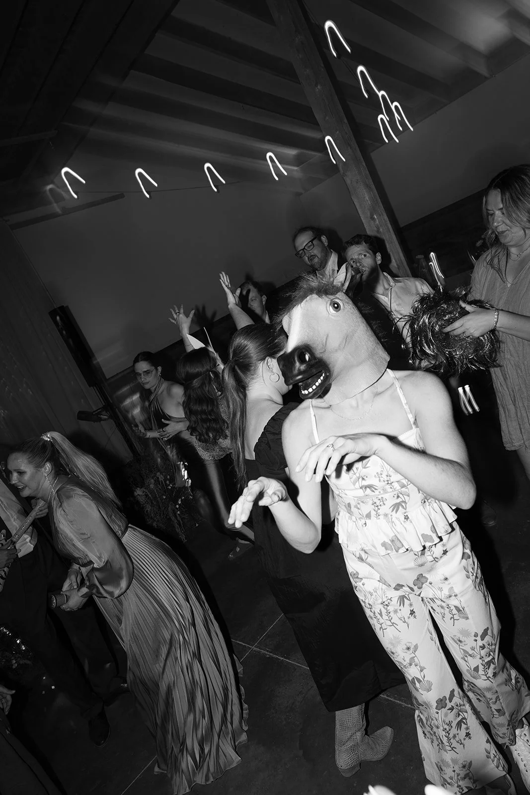 Bride in horse mask dancing with guests