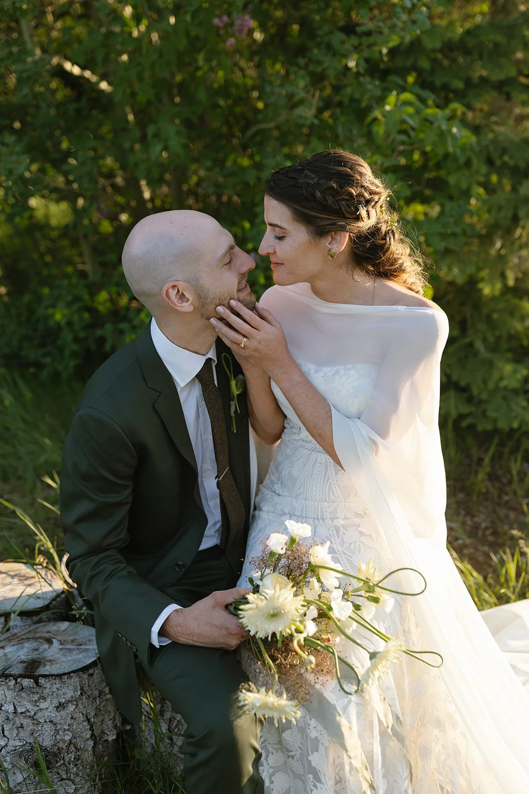 Bride sitting on grooms lap holding his face