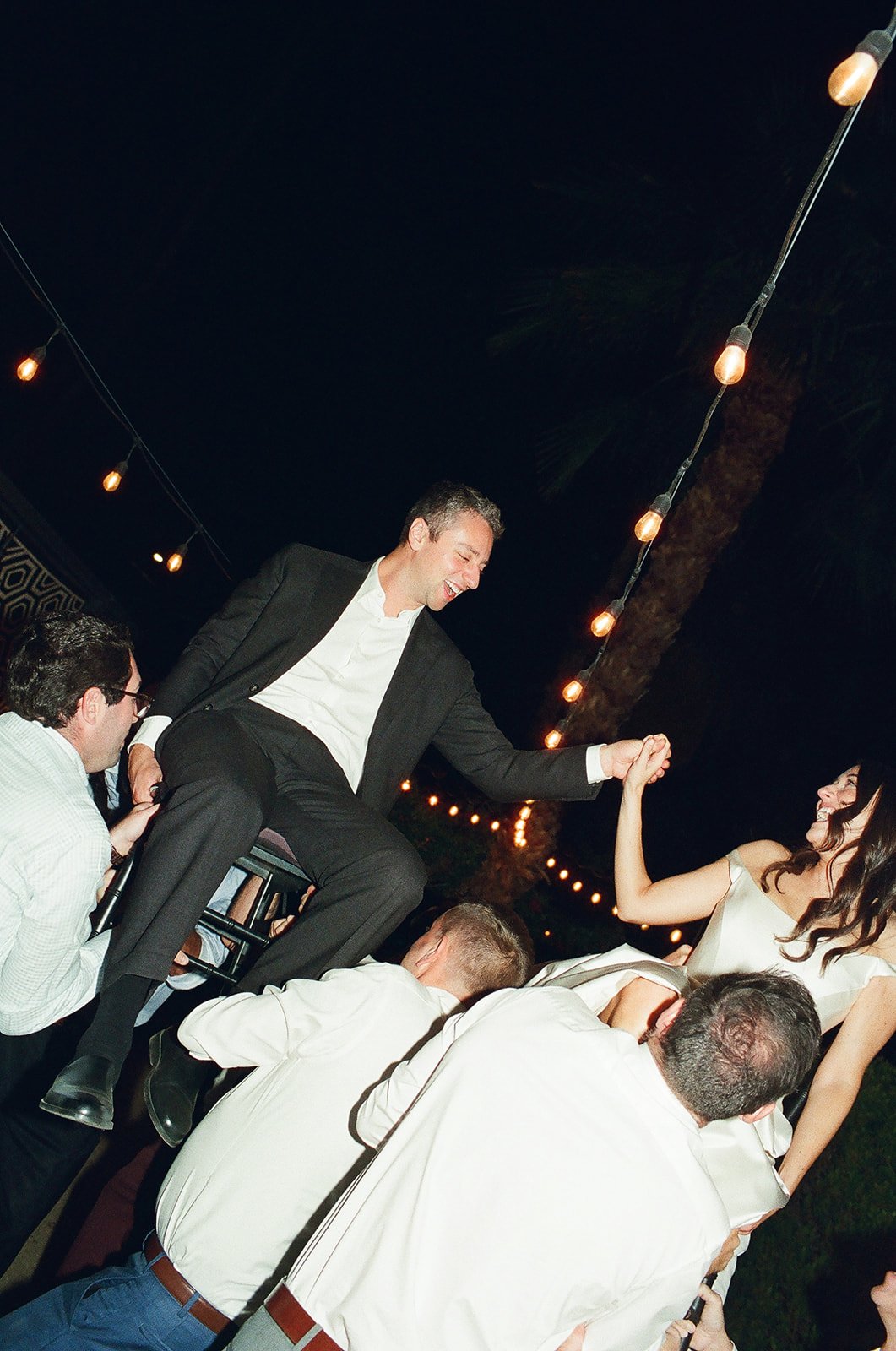 Bride and groom holding hands in hora