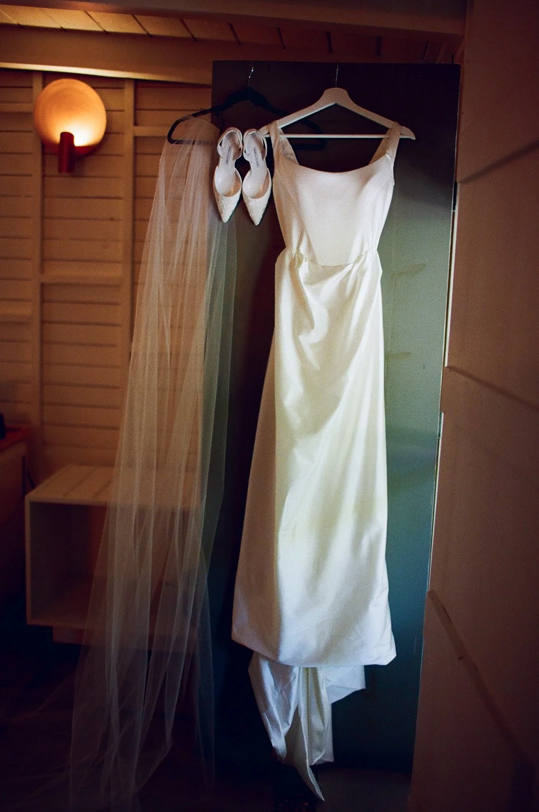 Wedding dress hanging with veil and shoes