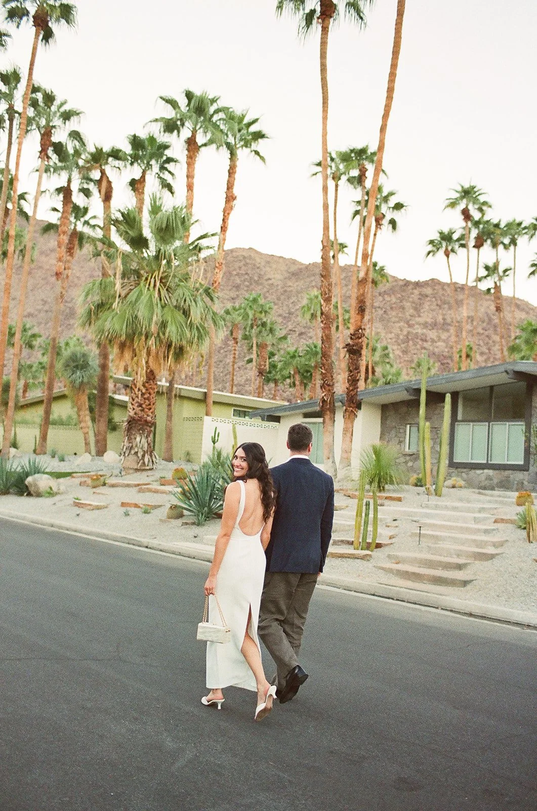 Couple walking away with bride smiling back at camera