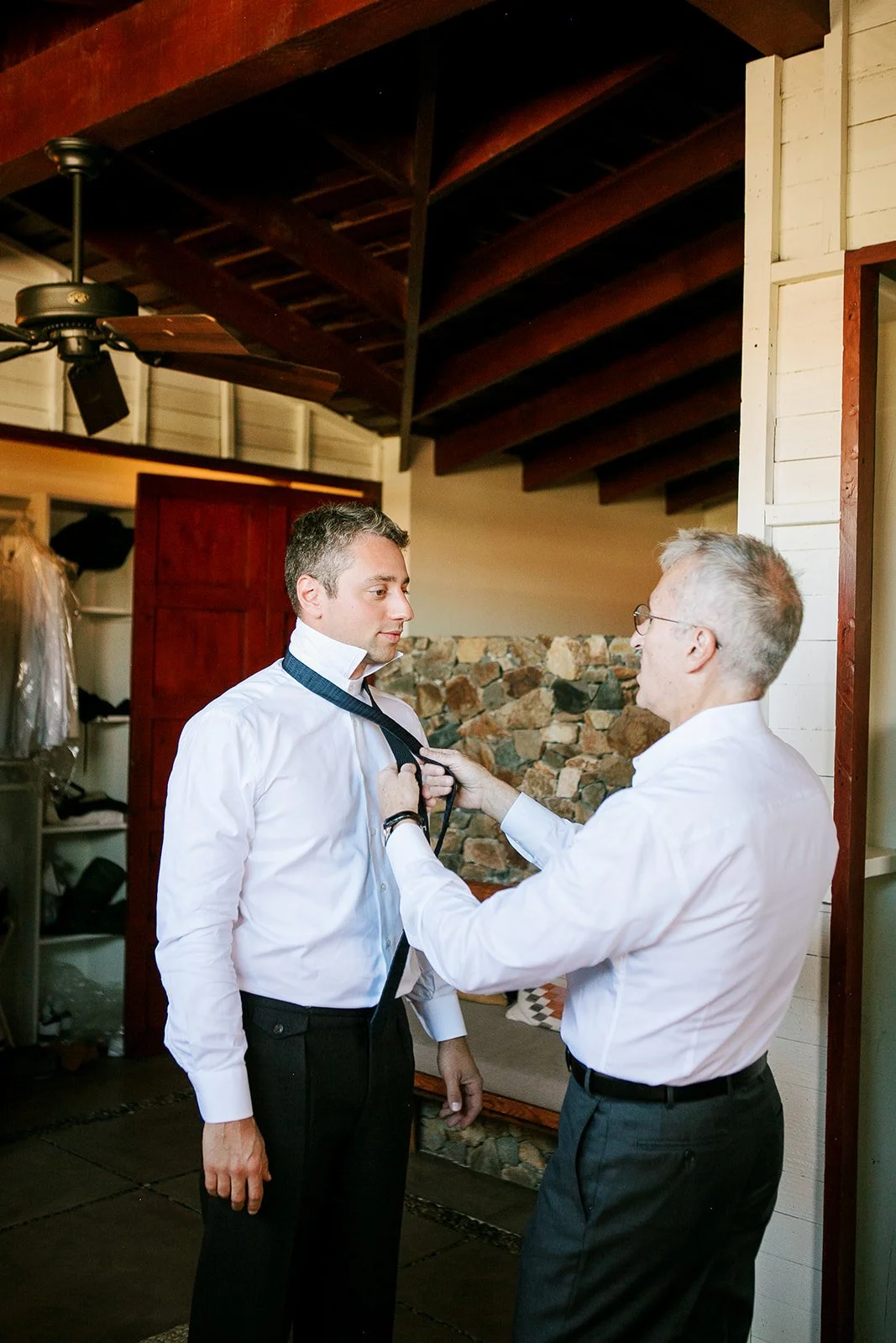 Groom's father putting on groom's tie