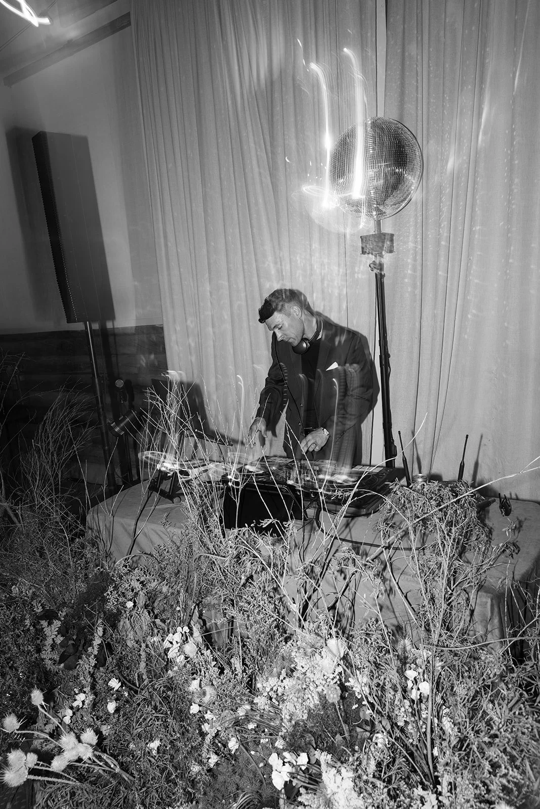 DJ playing music with florals in front