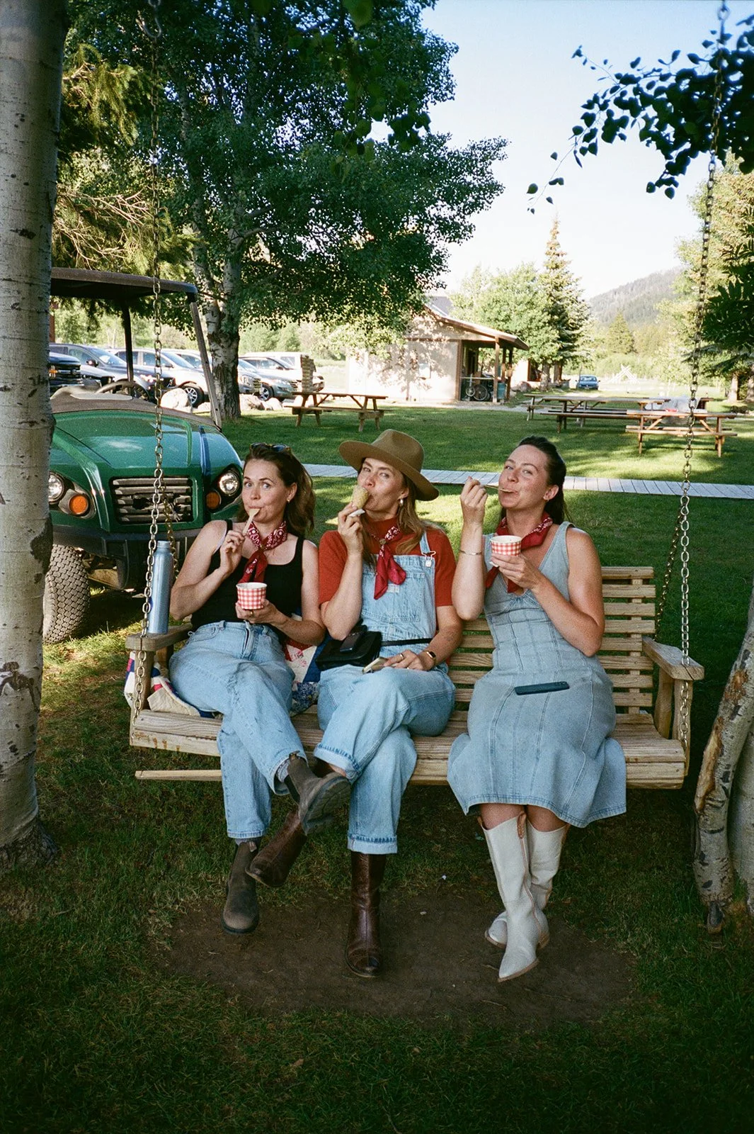 Three guests sitting on swing bench eating ice cream