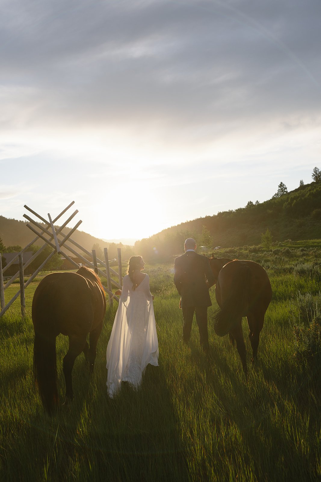 Bride and groom leading horses into distance