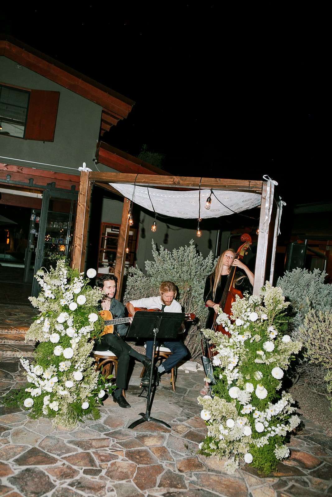 Band playing music sitting under chuppah