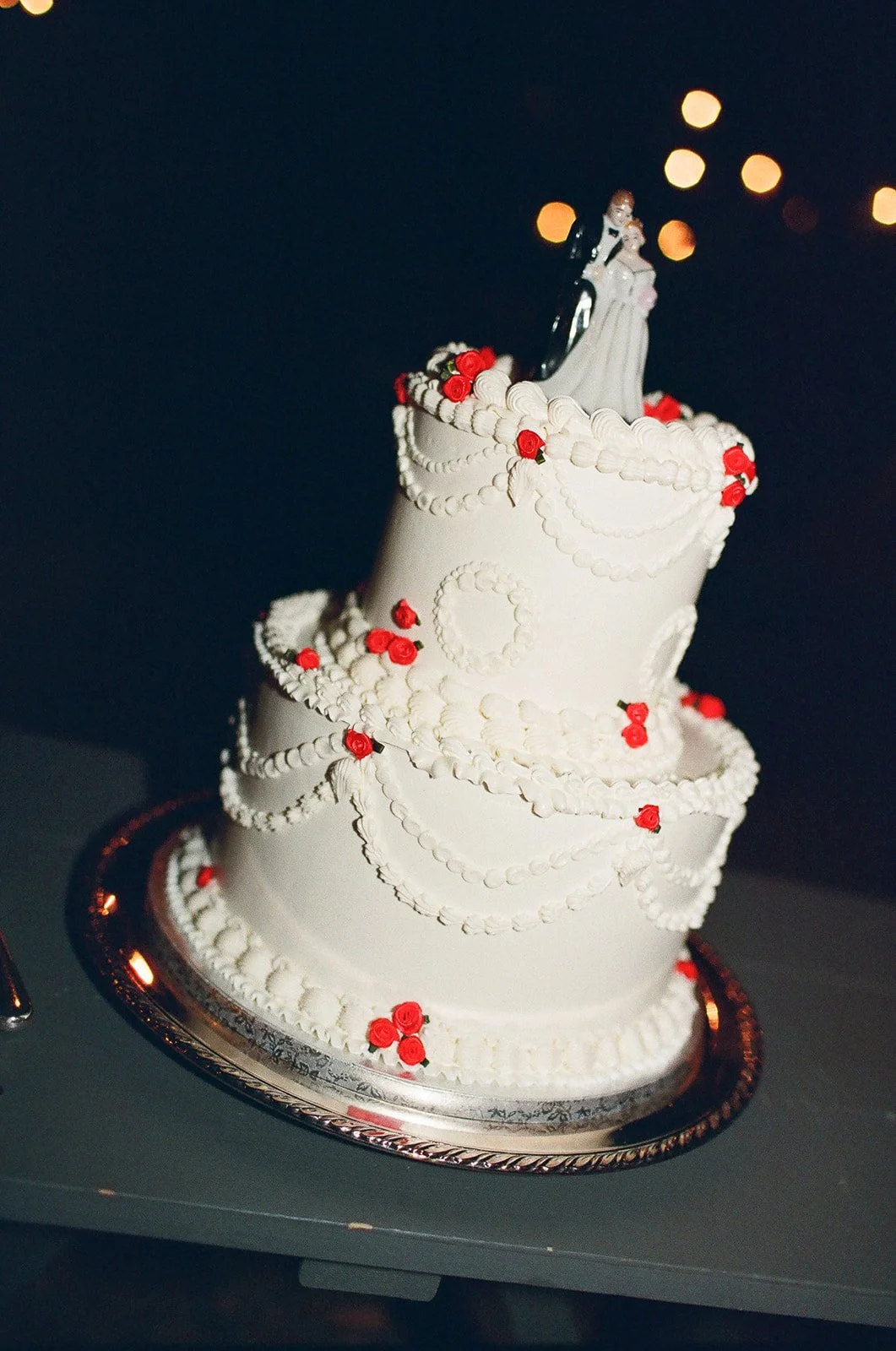 White wedding cake with red flowers