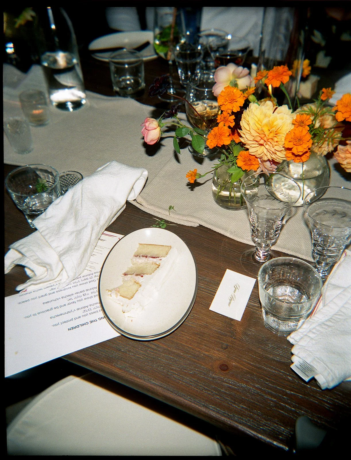 Slice of wedding cake sitting on dinner table