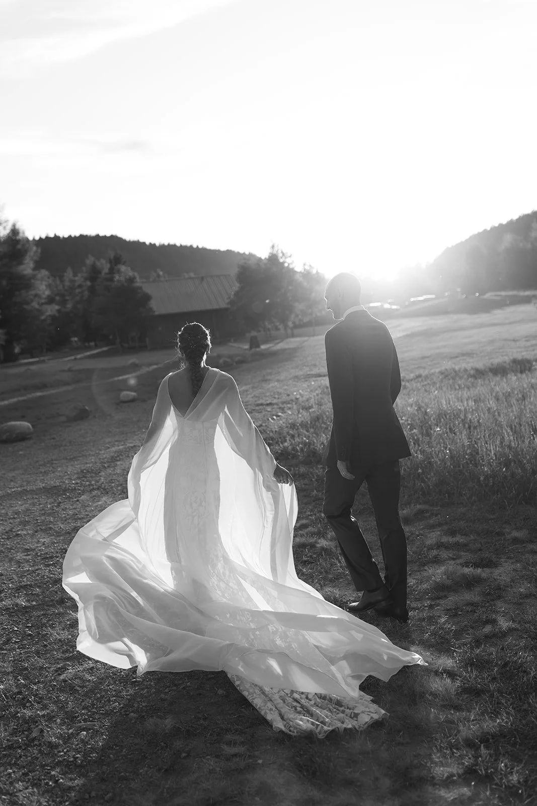 Bride and groom holding hands with gown flowing behind her