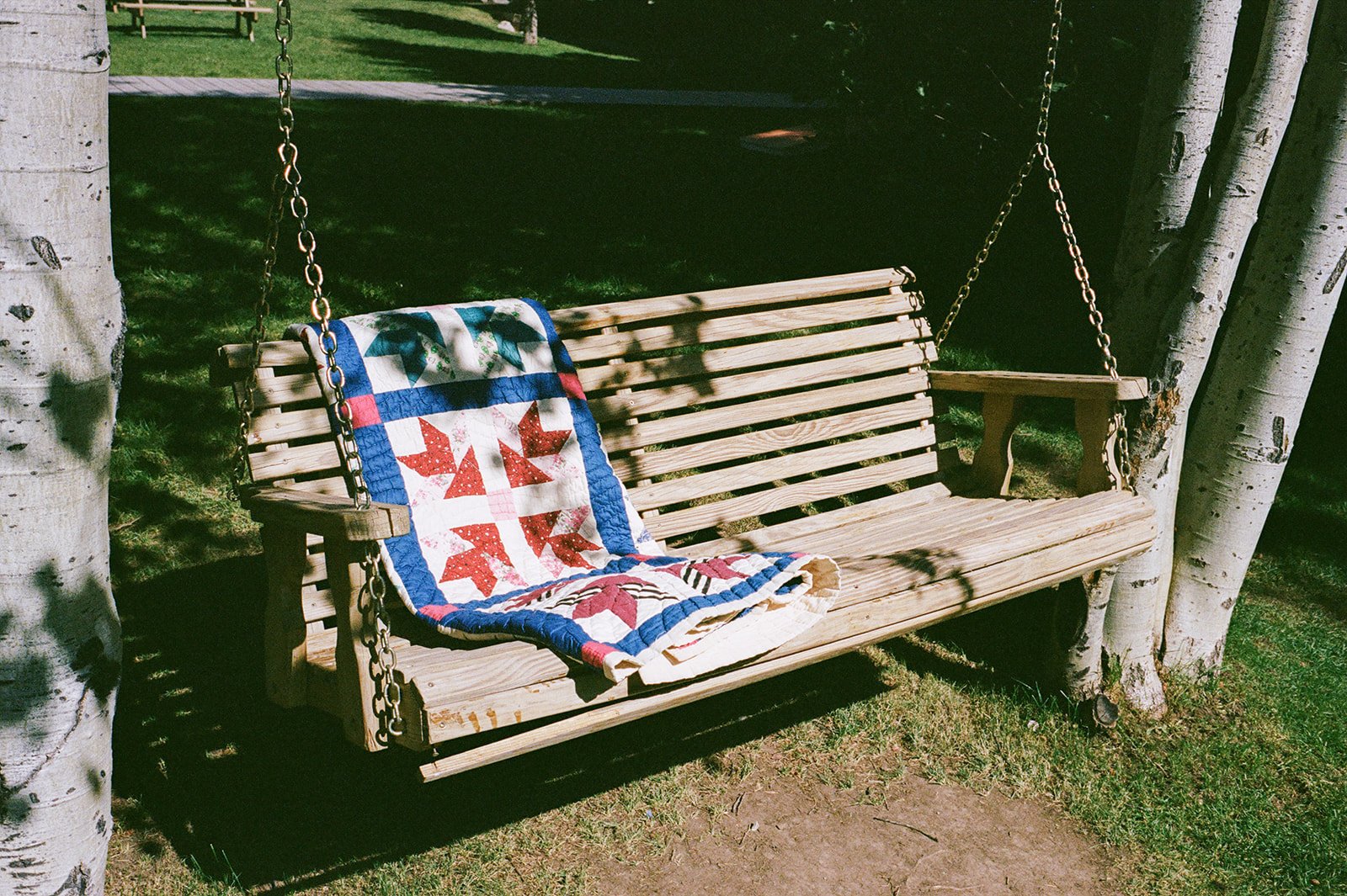 Hanging swing bench with quilt on it