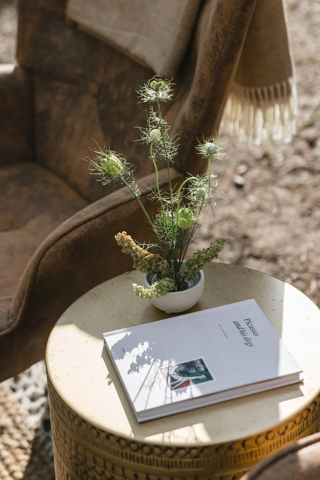 Picasso book sitting with flower arrangement on side table outside