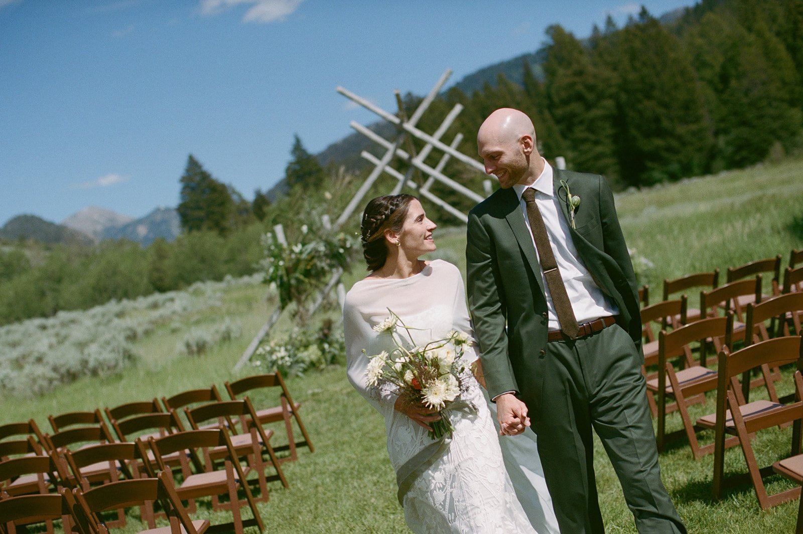 Bride and groom walking down aisle holding hands
