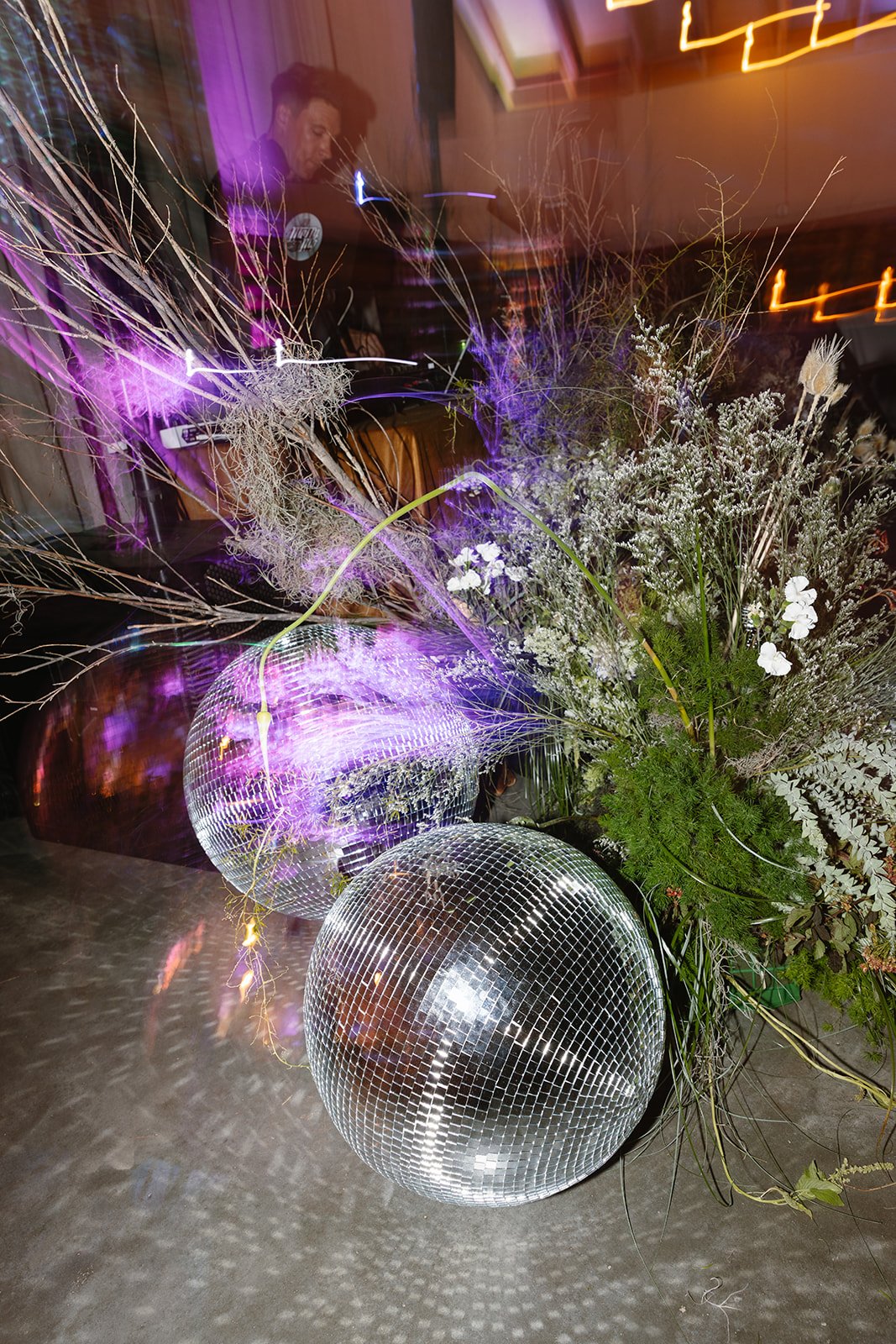 Disco balls shining with dj behind