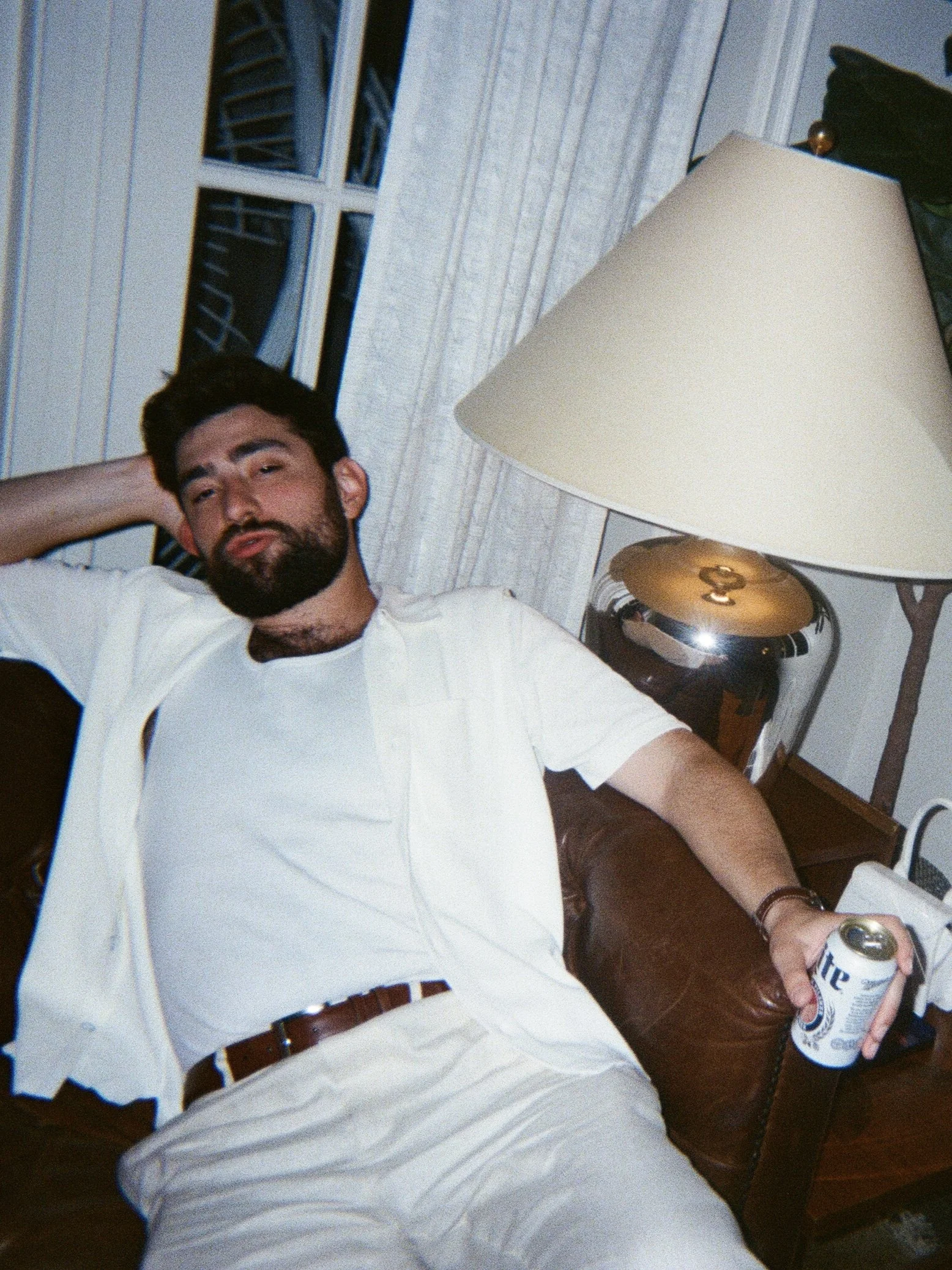 Groom at welcome party lounging with a beer