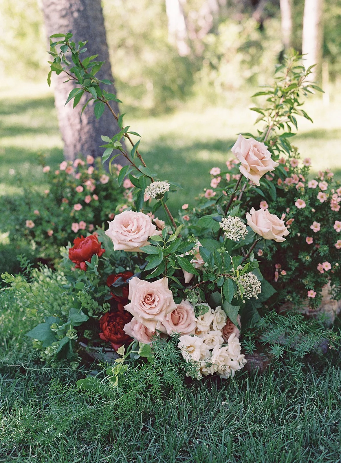 Bridal bouquet on the ground outside surrounded by trees
